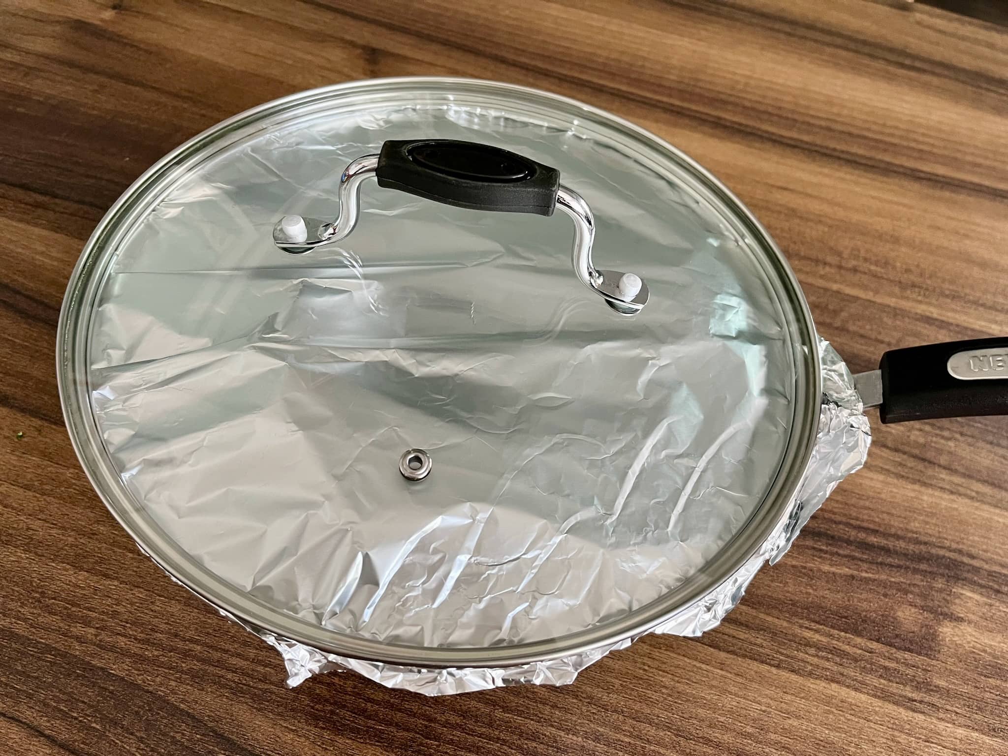 Pot covered with aluminium foil and the lid