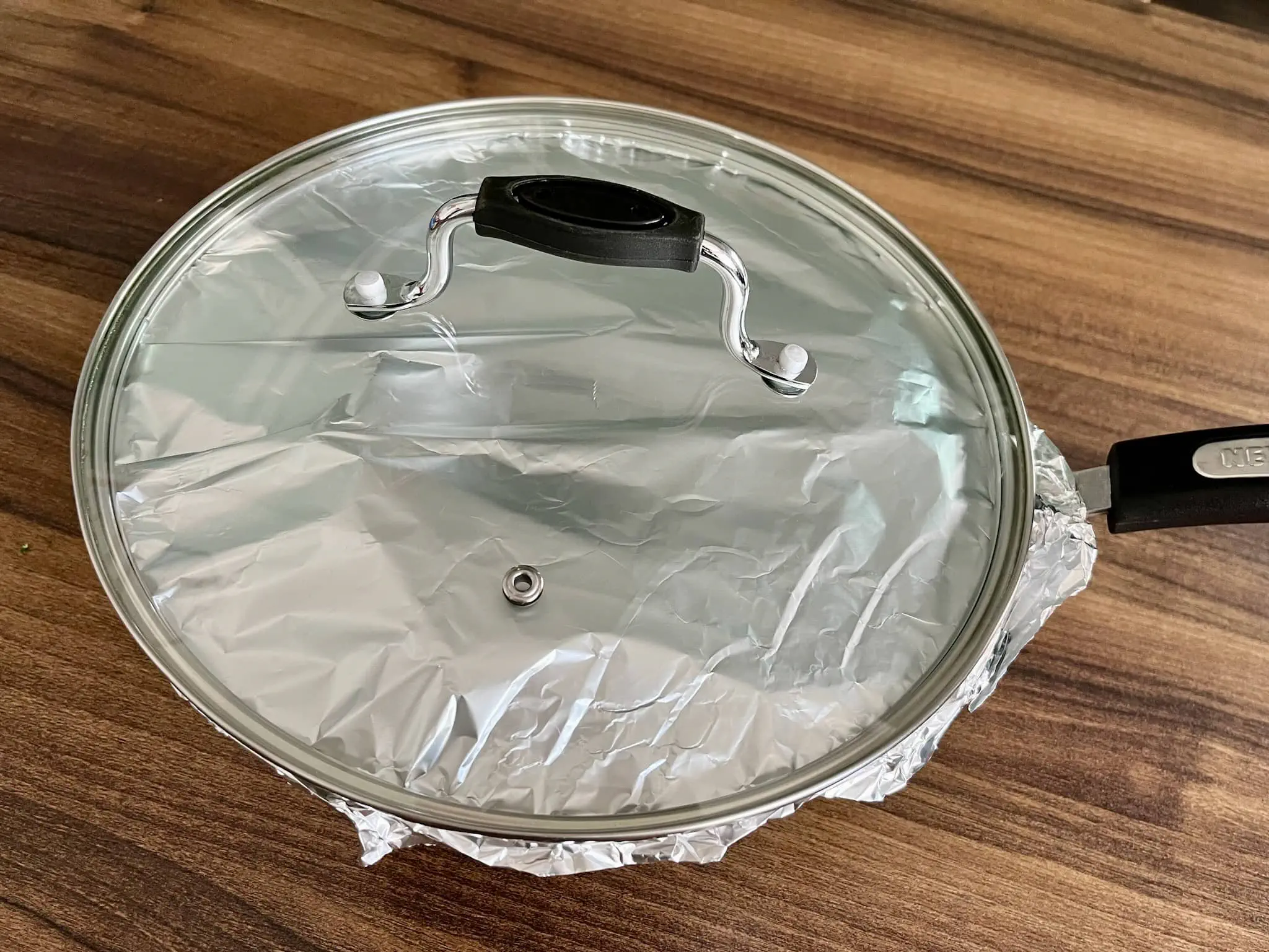 Garnek przykryty folią aluminiową i pokrywką