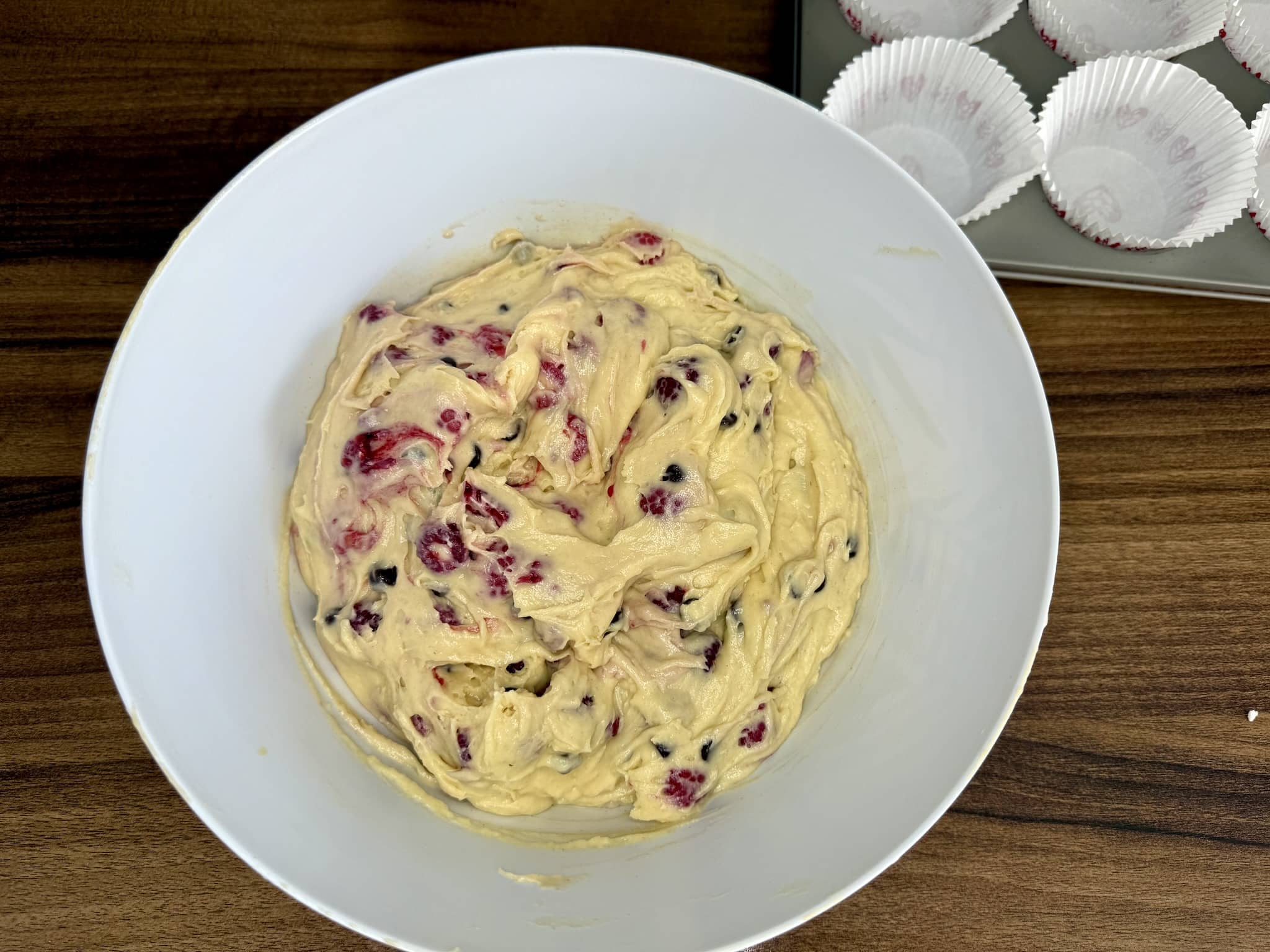 Muffins batter with mixed-in frozen raspberries and chocolate chips