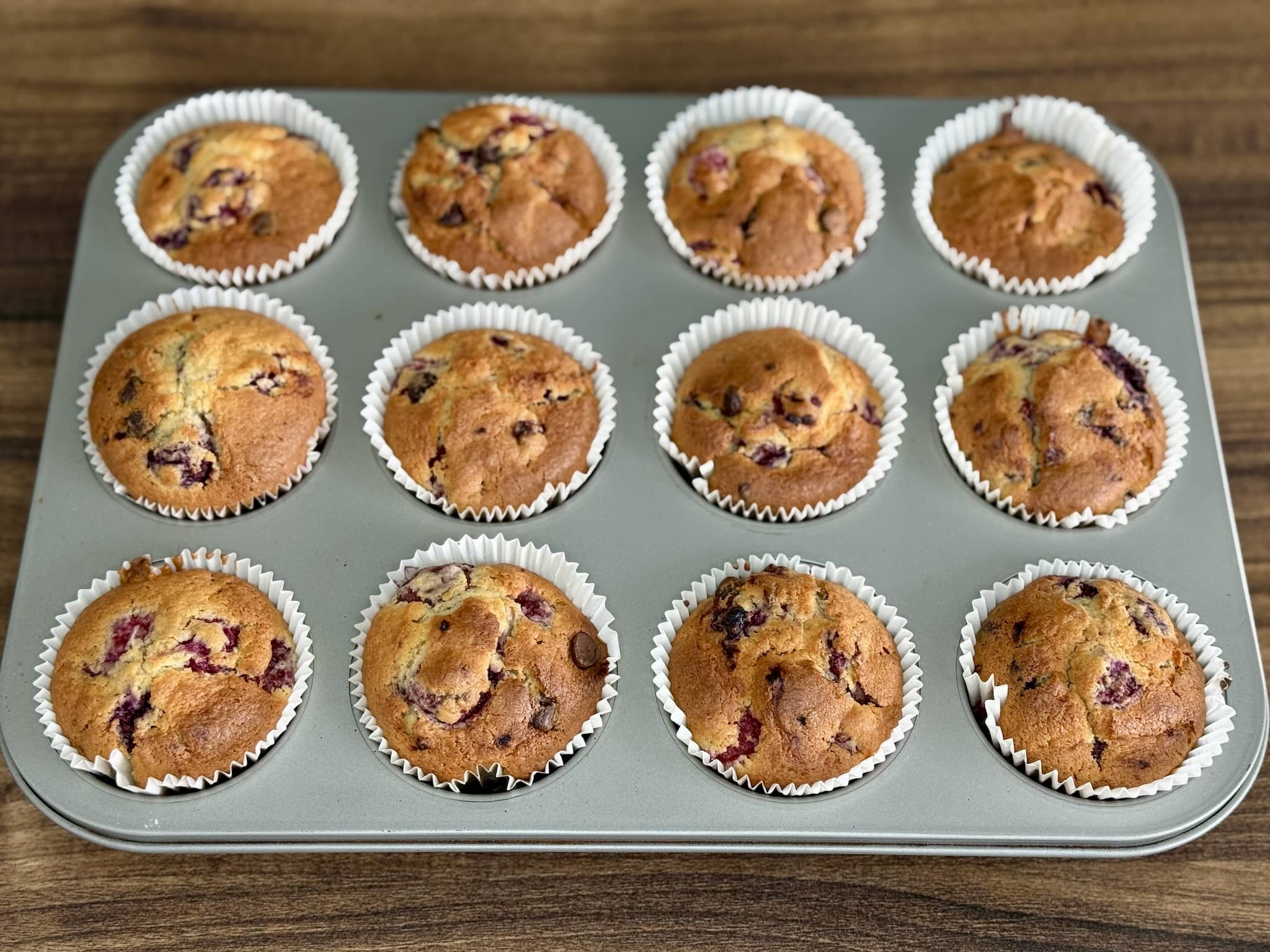 Nicely baked Raspberry and Chocolate Muffins still in a muffin tray