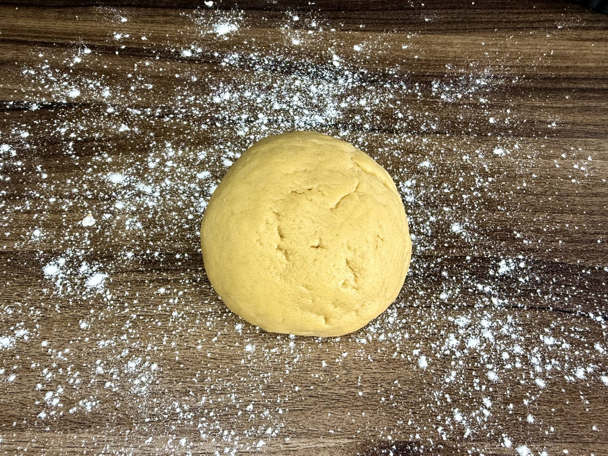A dough ball on a lightly dusted flour tabletop