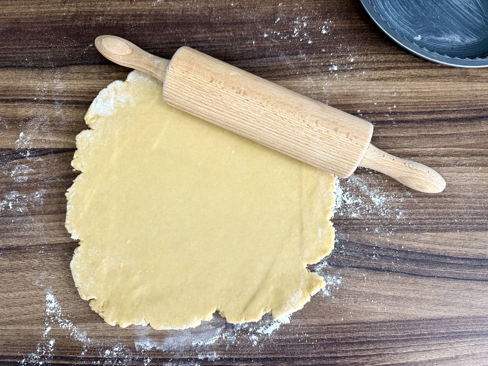 Rolled dough for tart with rolling pin on top