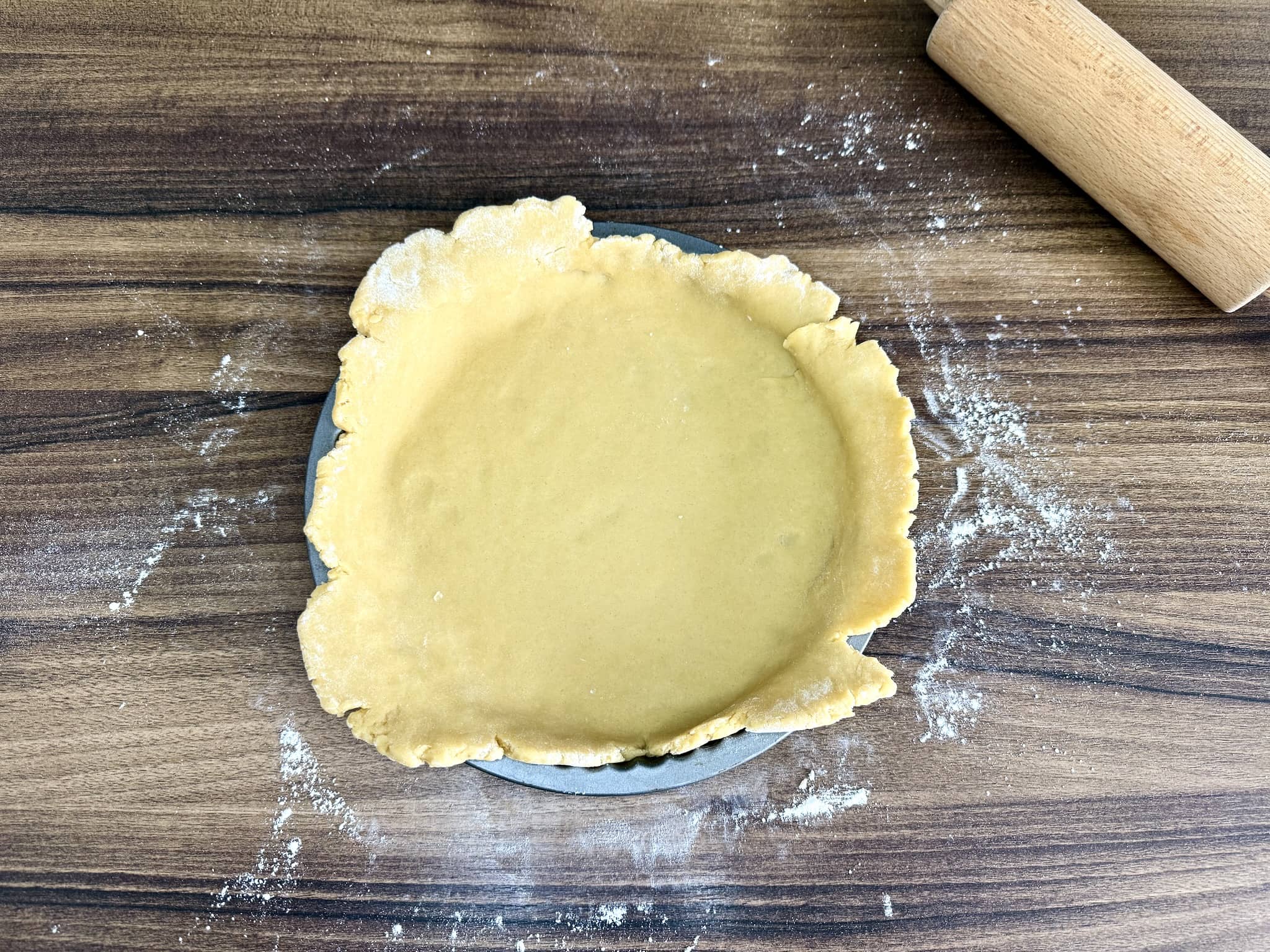 Dough transferred into tart tin with edges sticking out