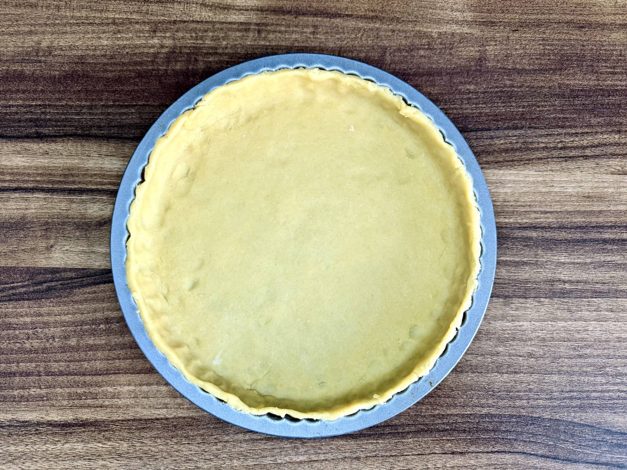 Dough in tart tin with trimmed edges