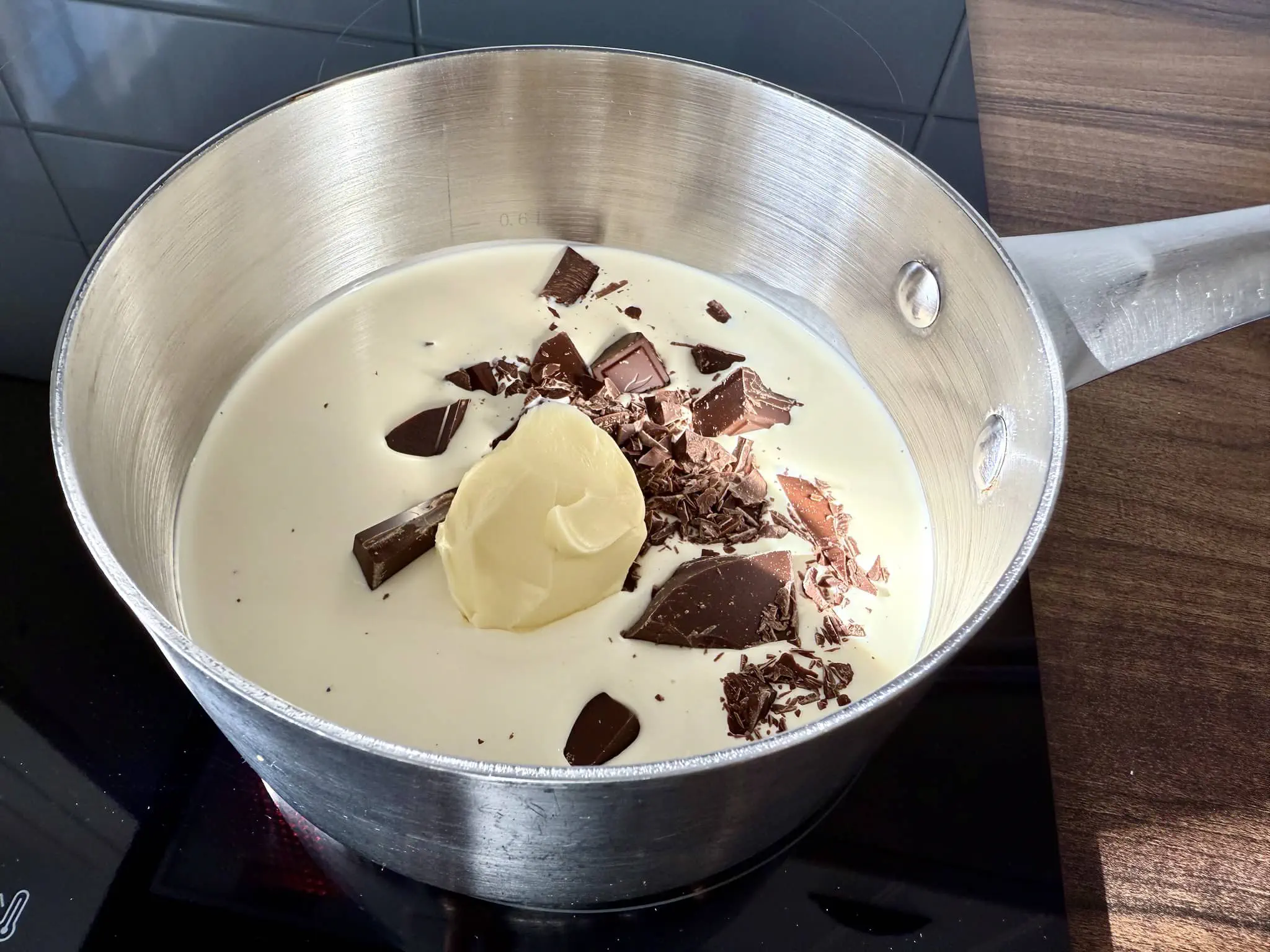 Śmietanka kremówka, masło i czekolada w garnku na kuchence