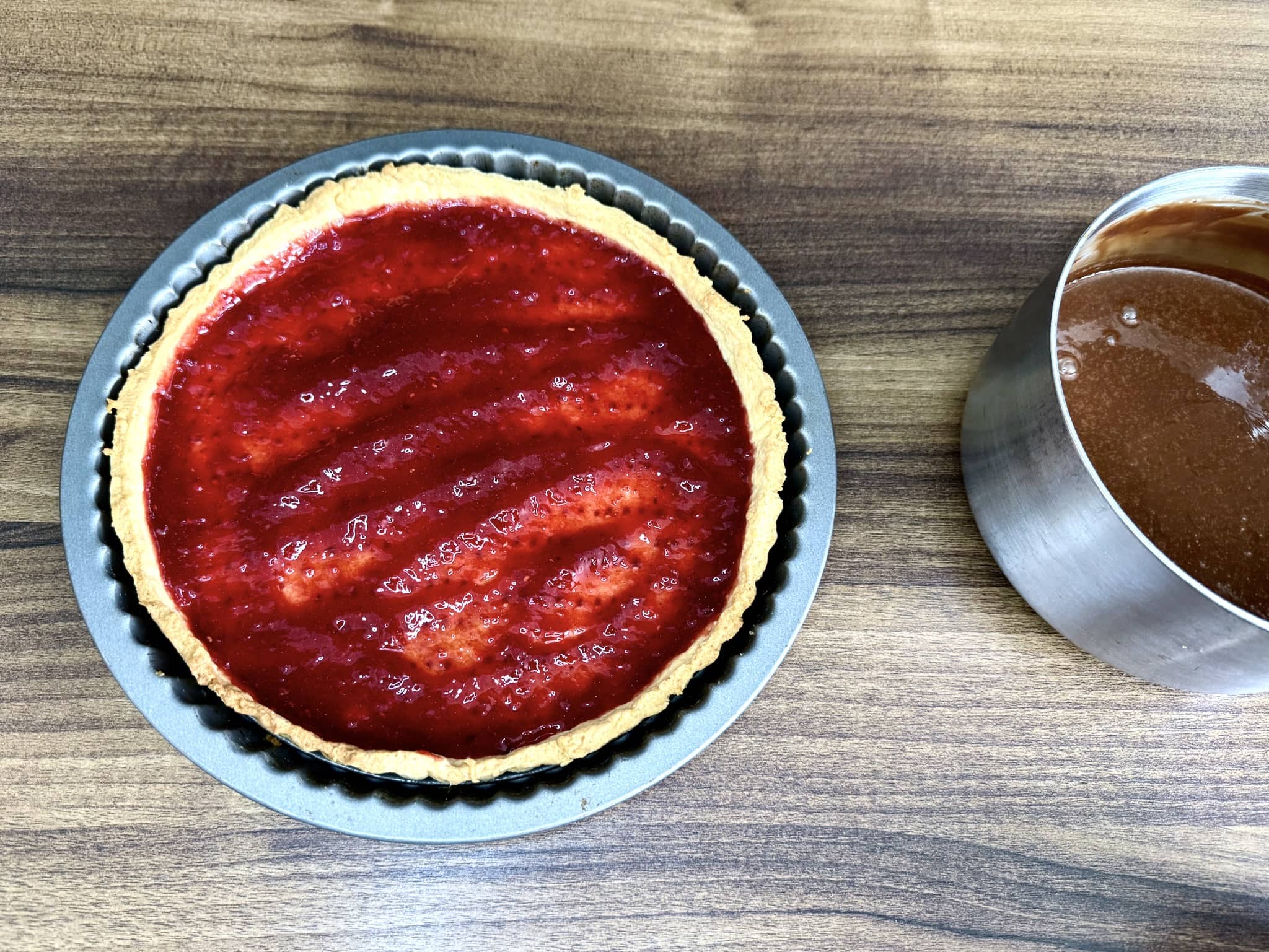 Tart base, still in the tart tin, filled with jam at the bottom