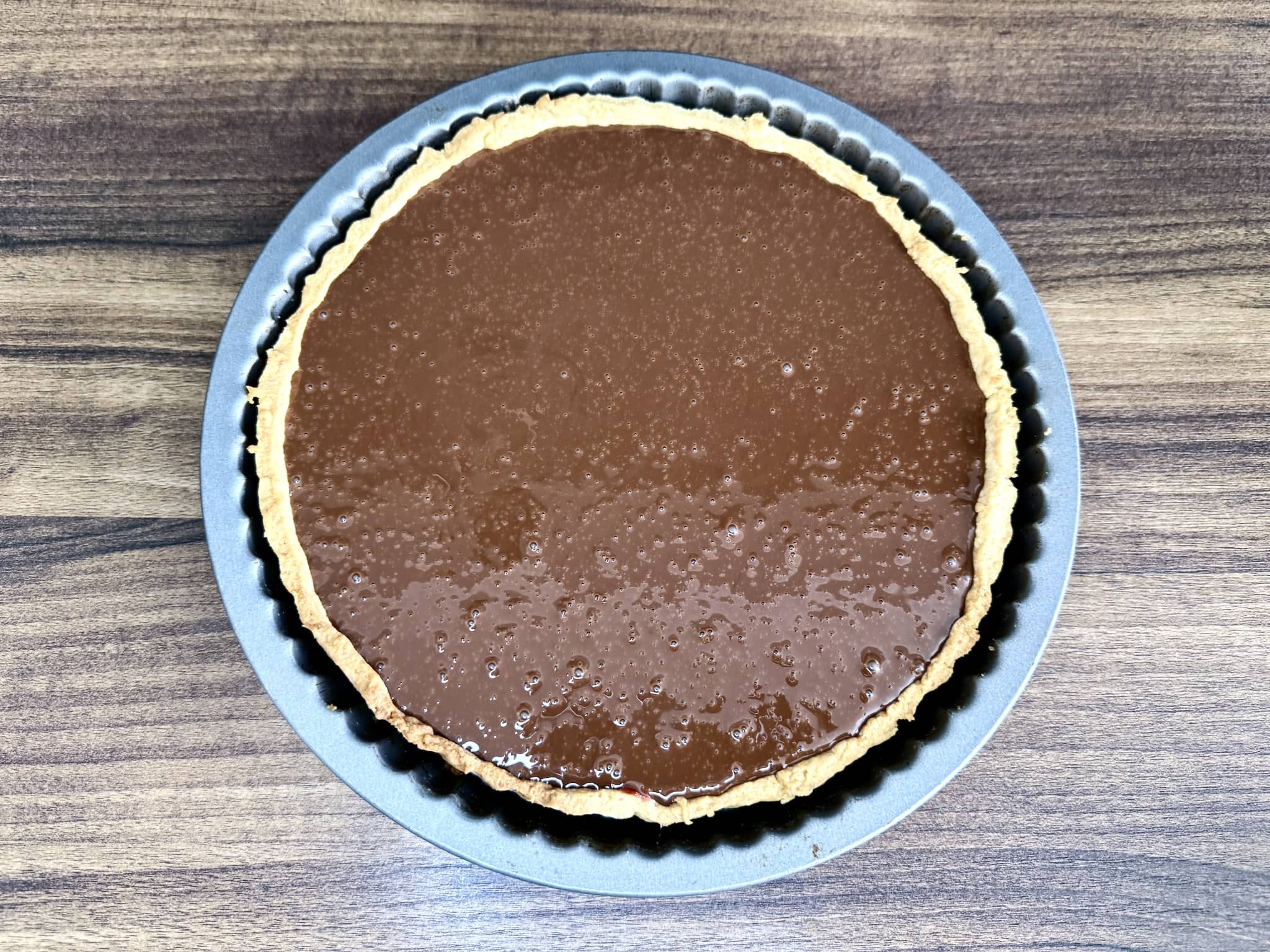 Tart base, still in the tart tin, filled with chocolate mixture