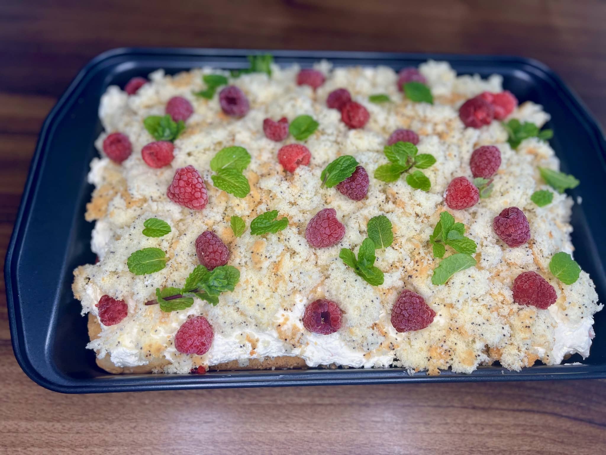 Cake decorated with mint and raspberries on top of the crumble