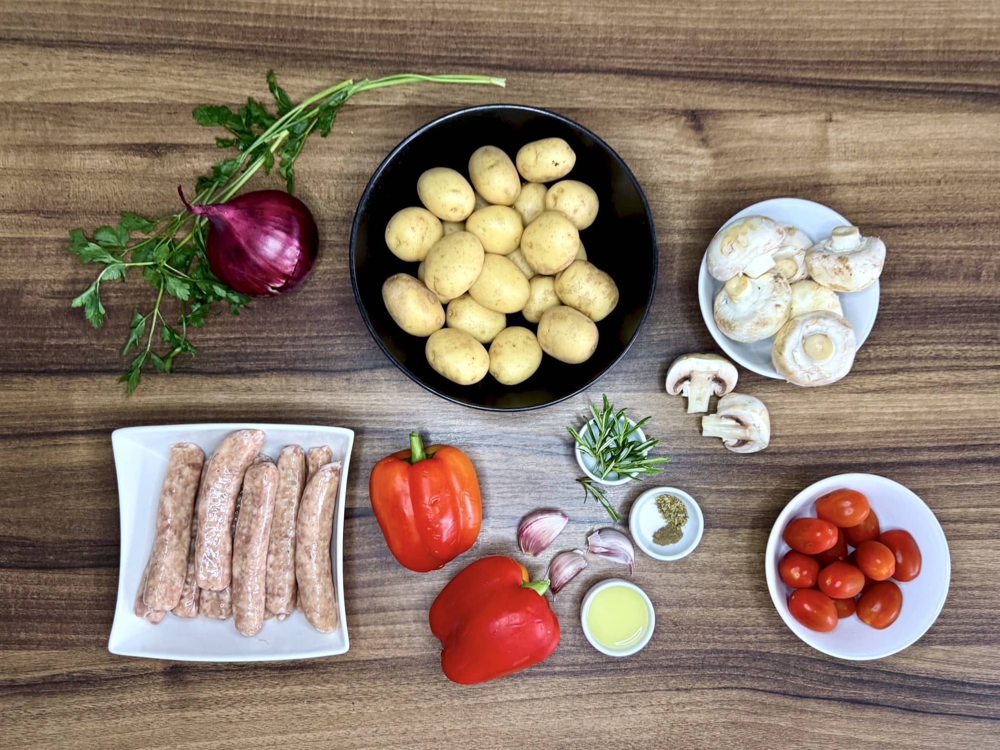 All ingredients on a tabletop, ready to make Roasted Sausage & Veg Traybake