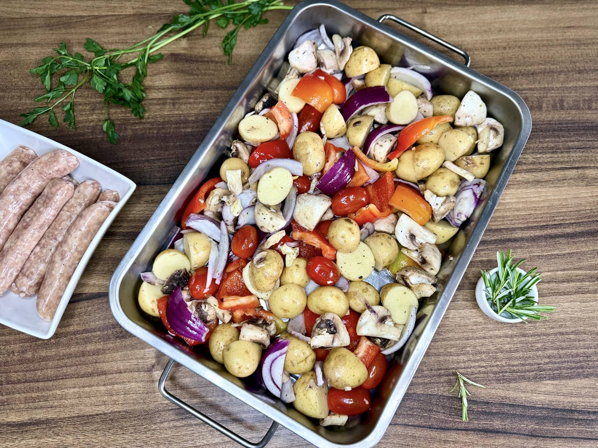 Vegetables arranged in a single layer at the bottom of a baking tray before placing in the oven