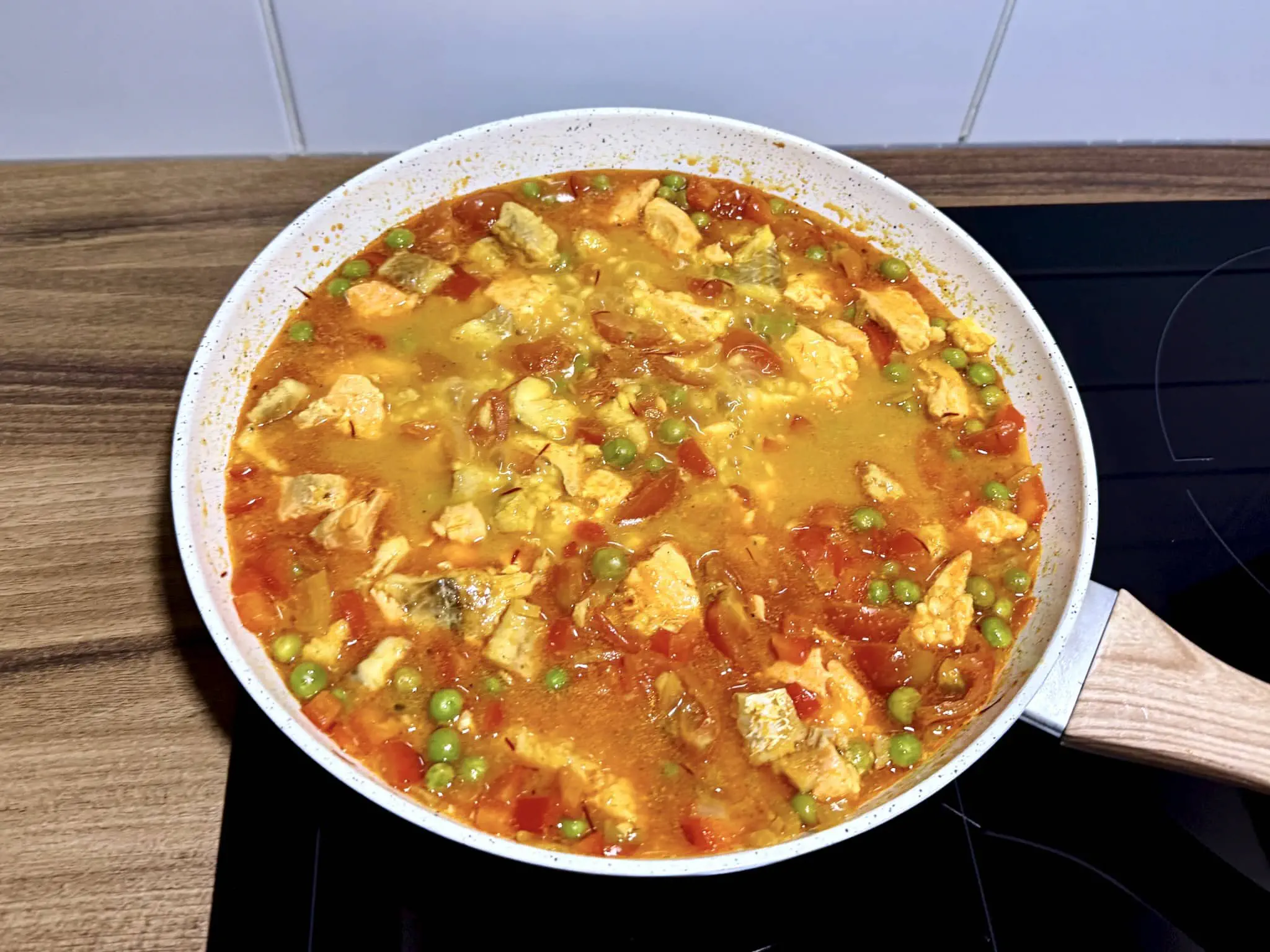 Paella z Owocami Morza z Łososiem i Białą Rybą nabiera kształtu na patelni