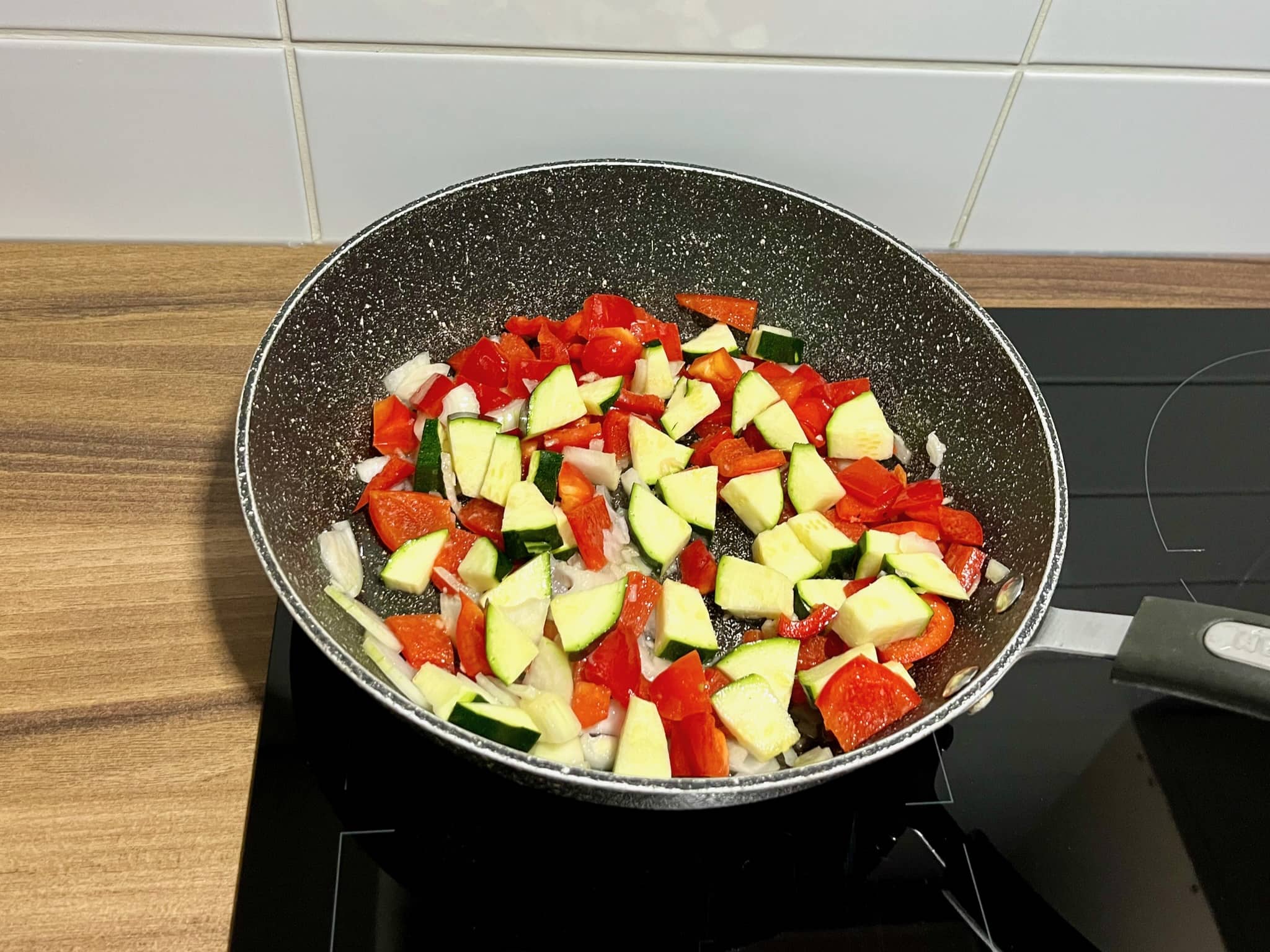 Courgette and bell pepper added to the pan with the onions and garlic