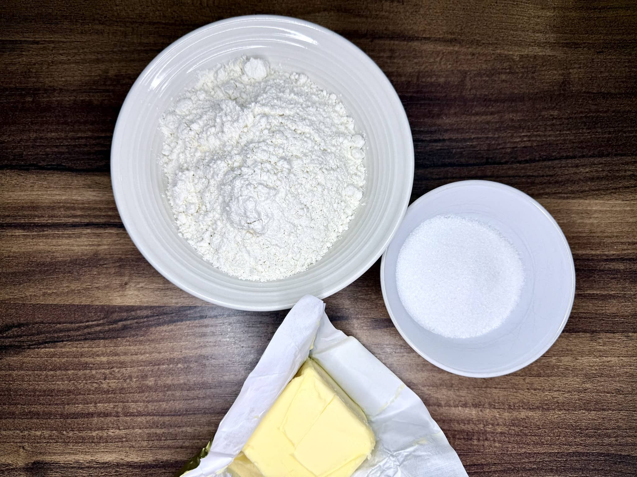 Flour in a bowl with butter and sugar ready to make biscuits