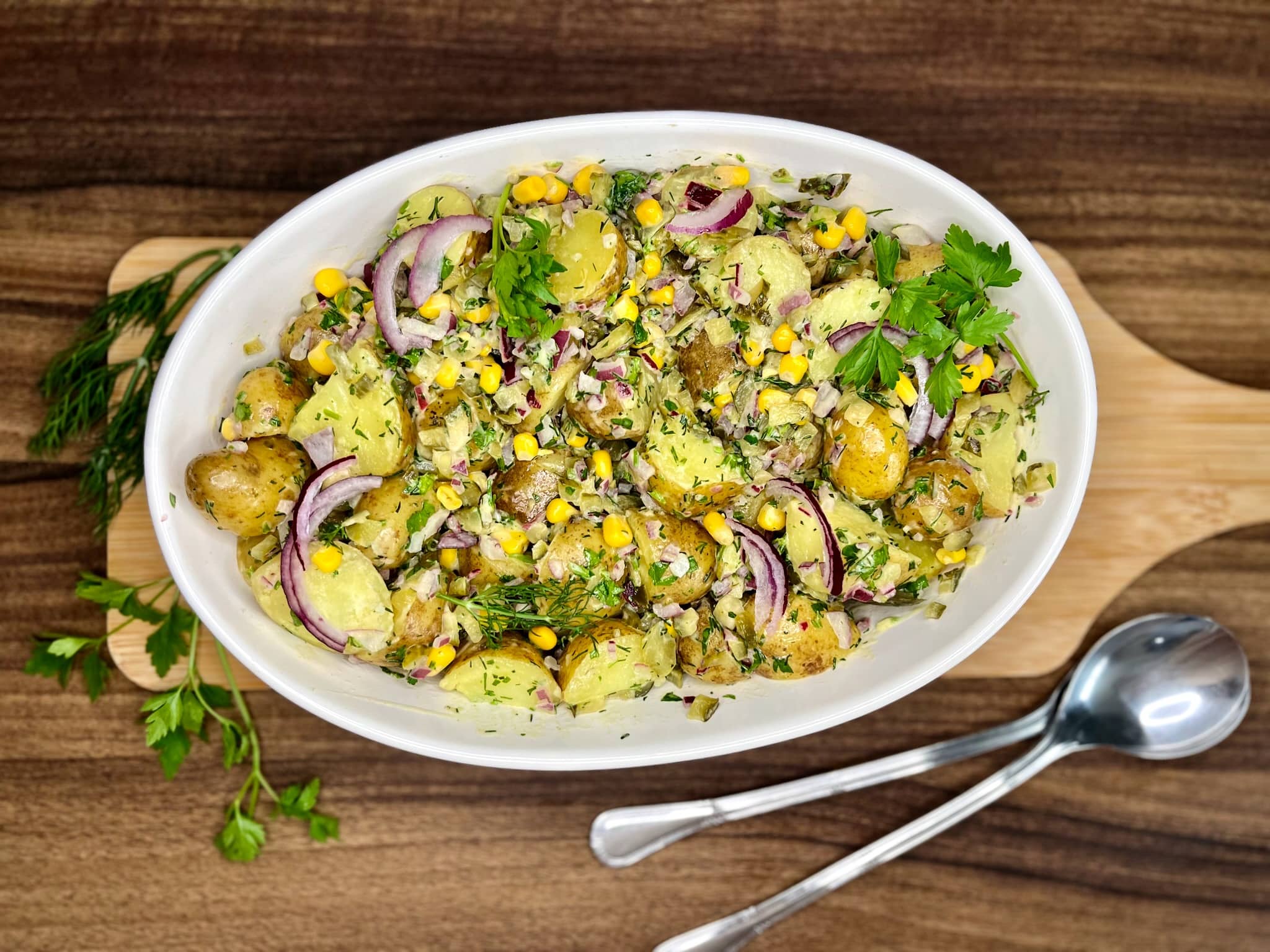 Simple Baby Potato Salad served and garnished with red onion and parsley