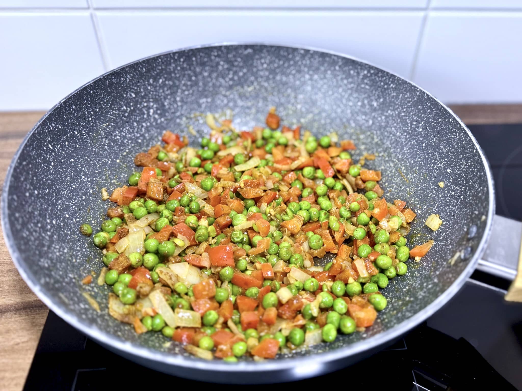 Warzywa na patelni posypane proszkiem curry