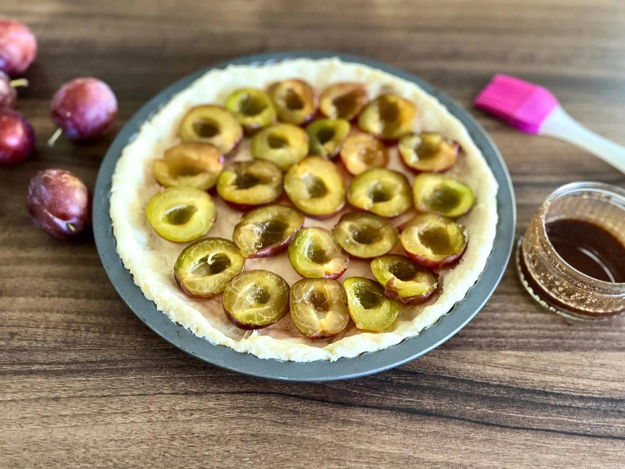 Śliwki posmarowane glazurą na cieście w formie