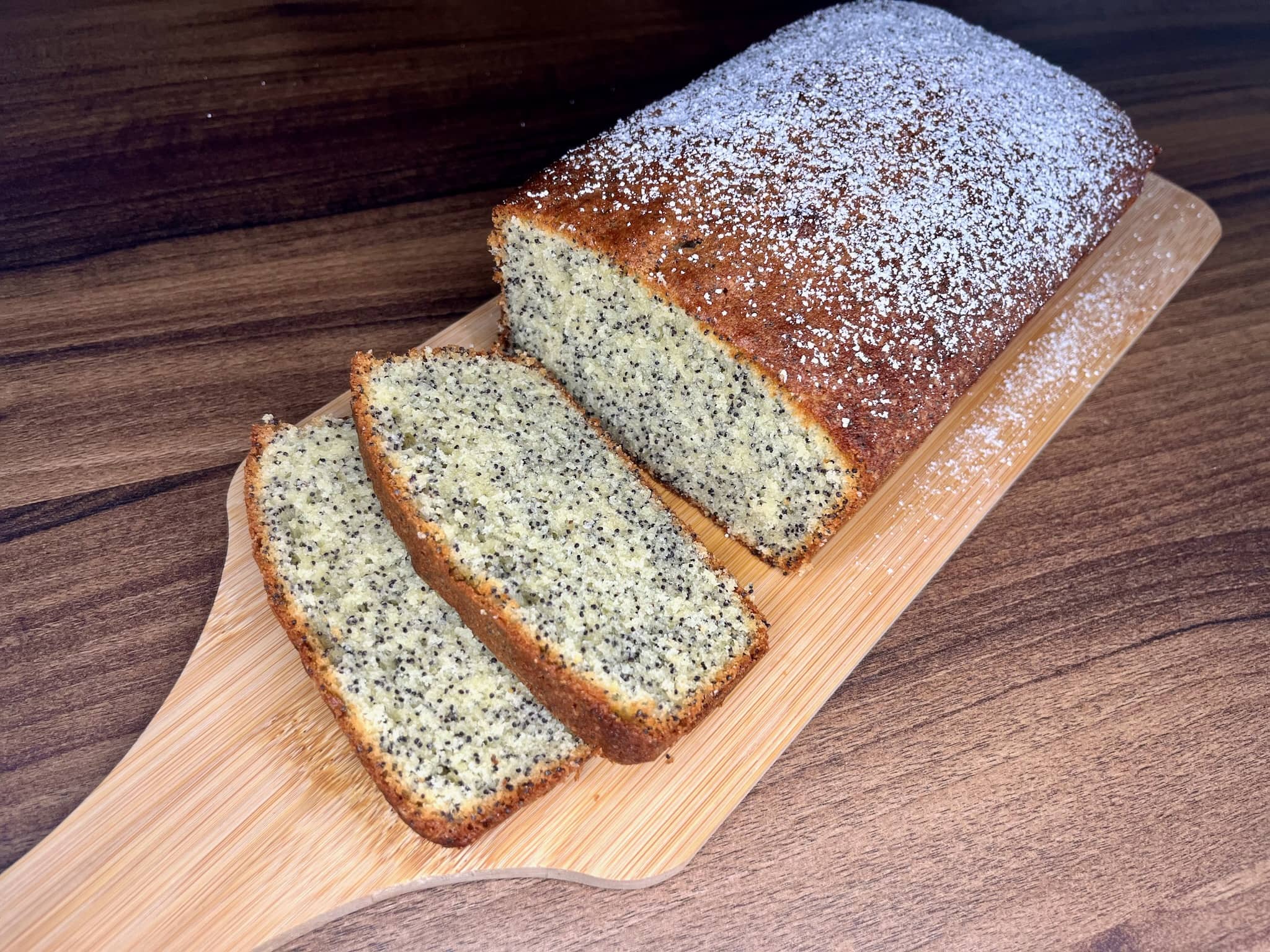 Slices of poppy seed loaf cake on a cutting board