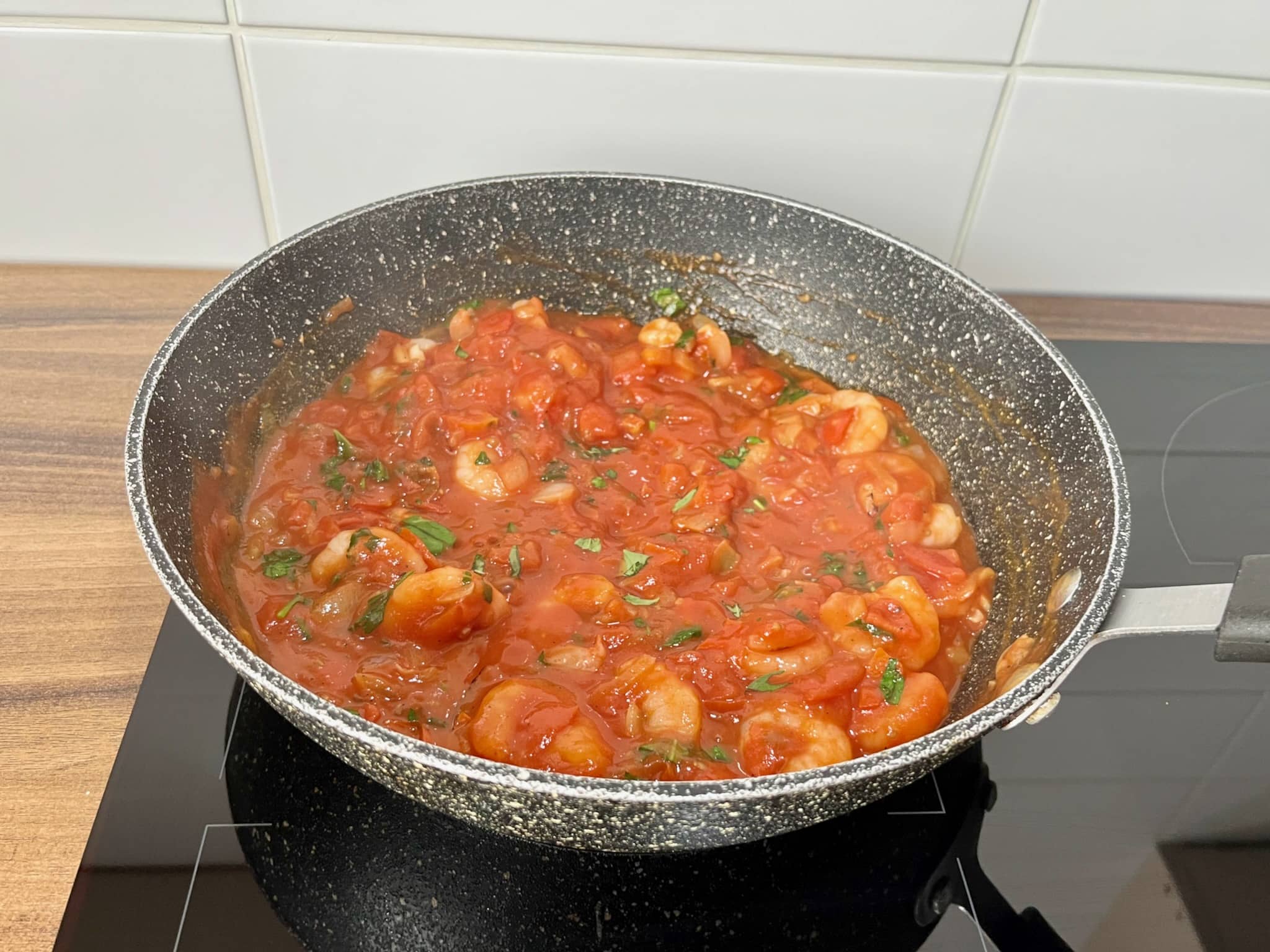 Tomatoes, onion, garlic, prawns and basil fried in a pan
