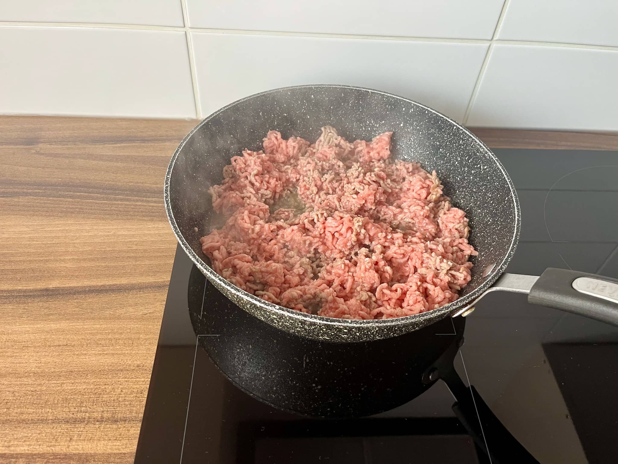 Minced meat frying in a pan until brown