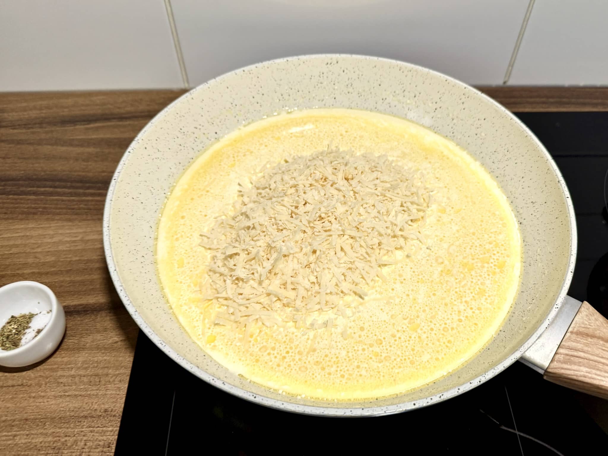 Grated Parmesan cheese added to the pan