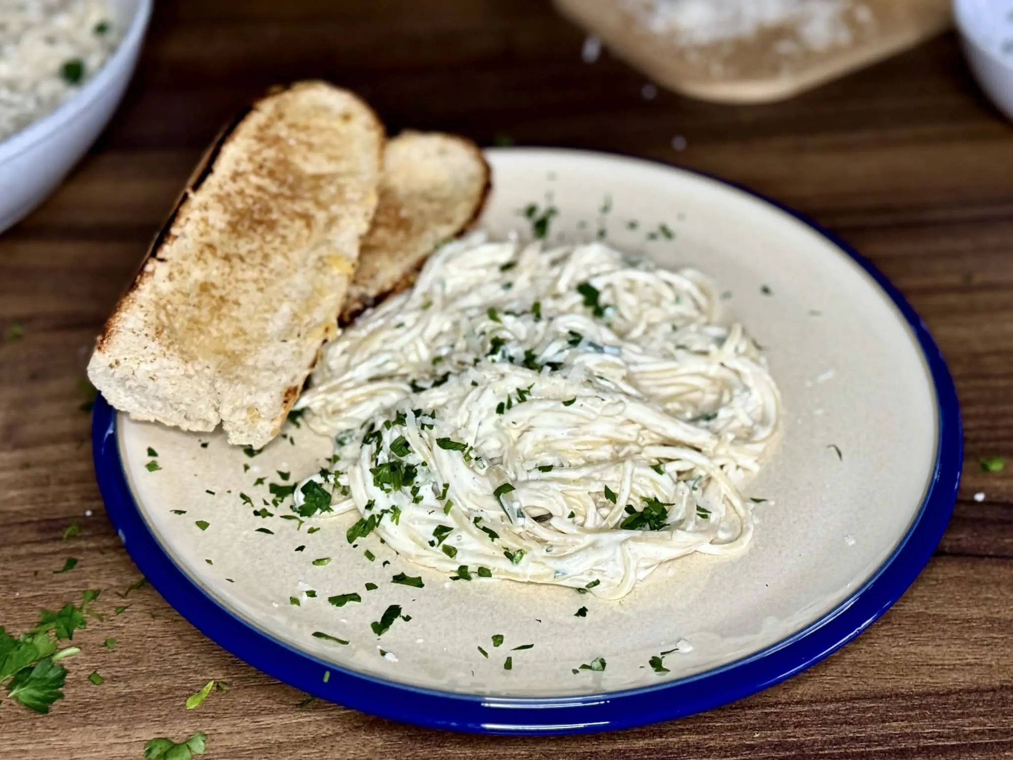 Porcja Spaghetti w sosie Alfredo z grzanką na talerzu