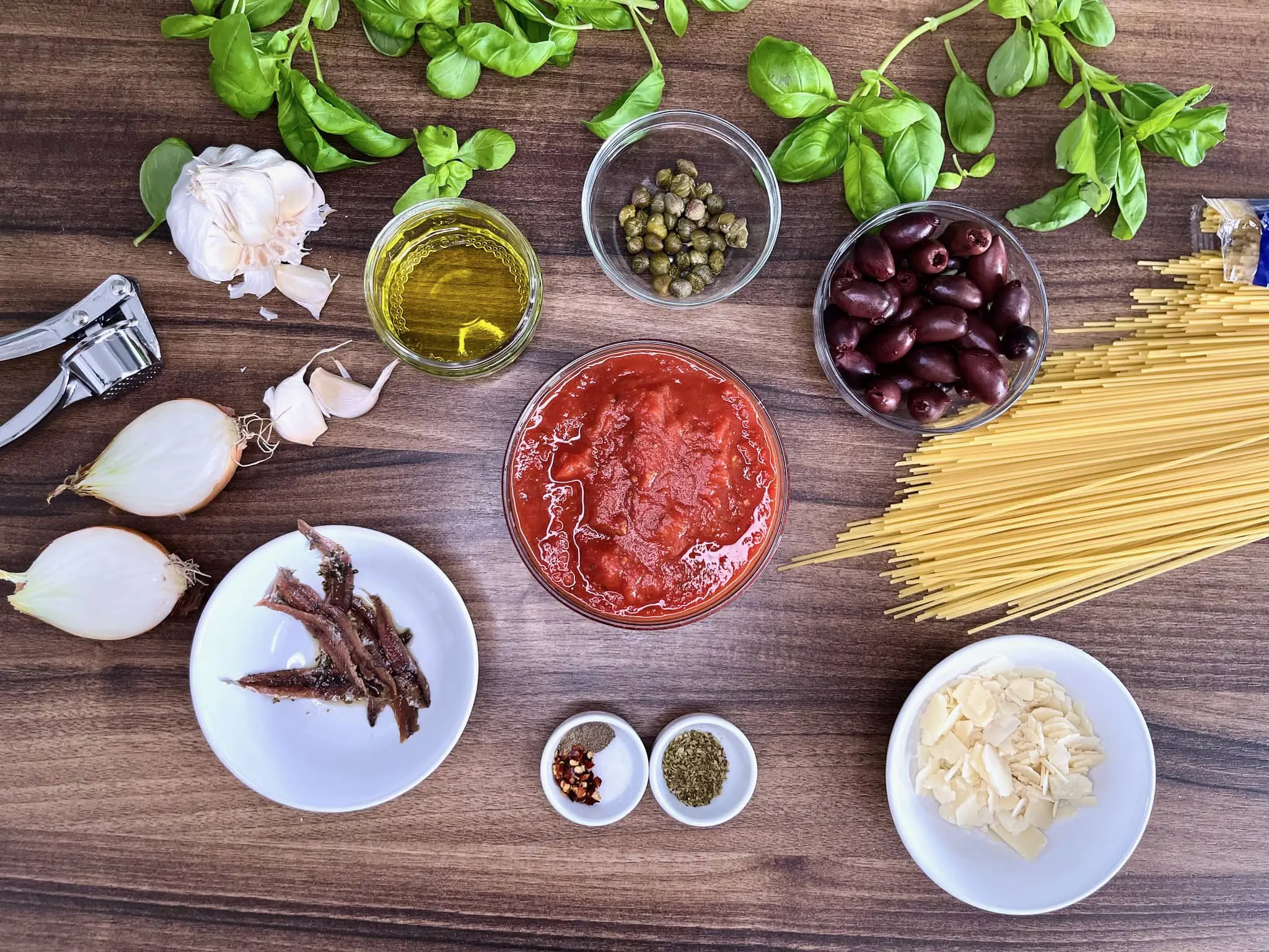 Wszystkie składniki na blacie gotowe do przygotowania Spaghetti Puttanesca