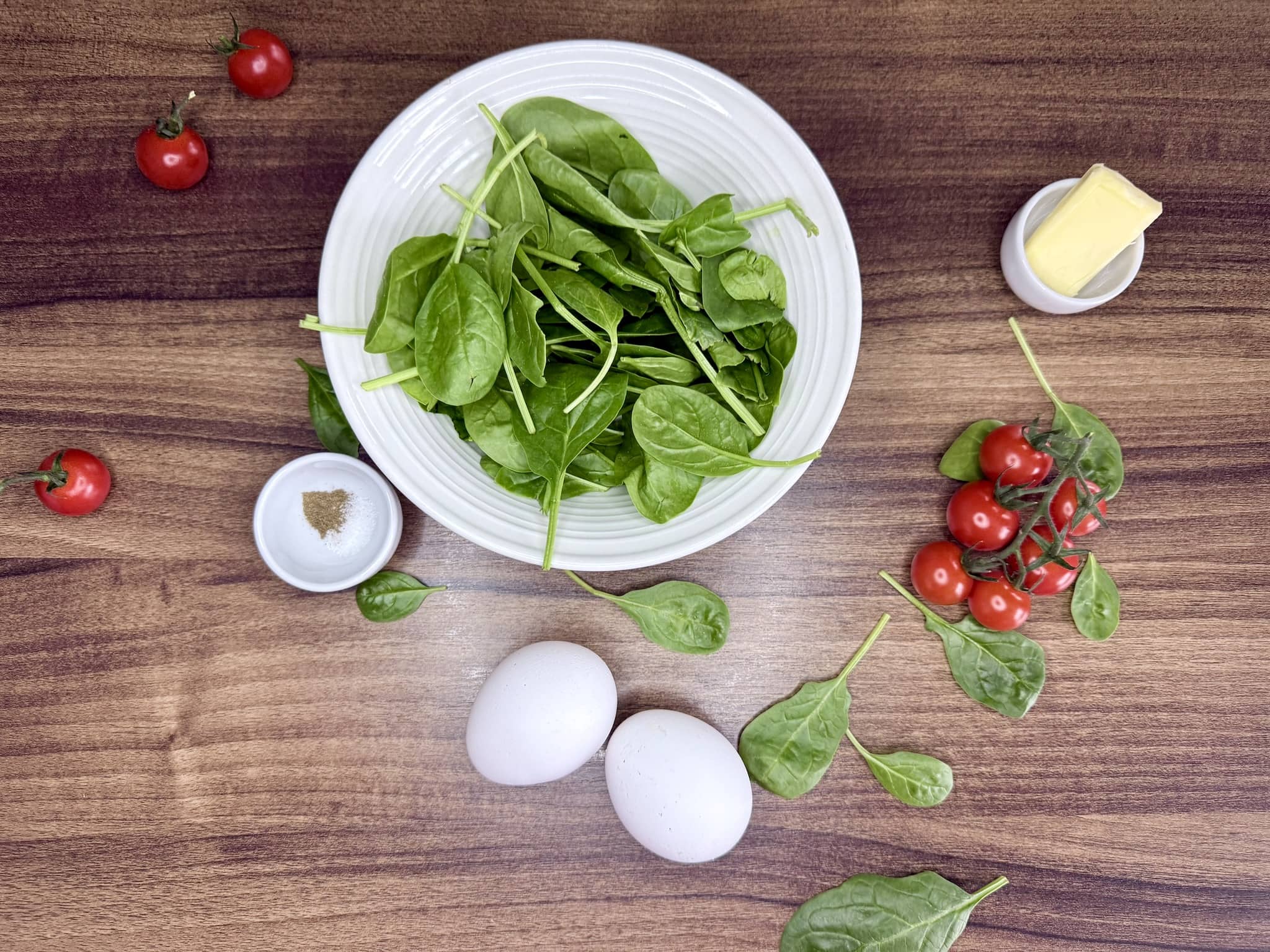 Ingredients for Spinach and Tomatoes Omelette on a tabletop