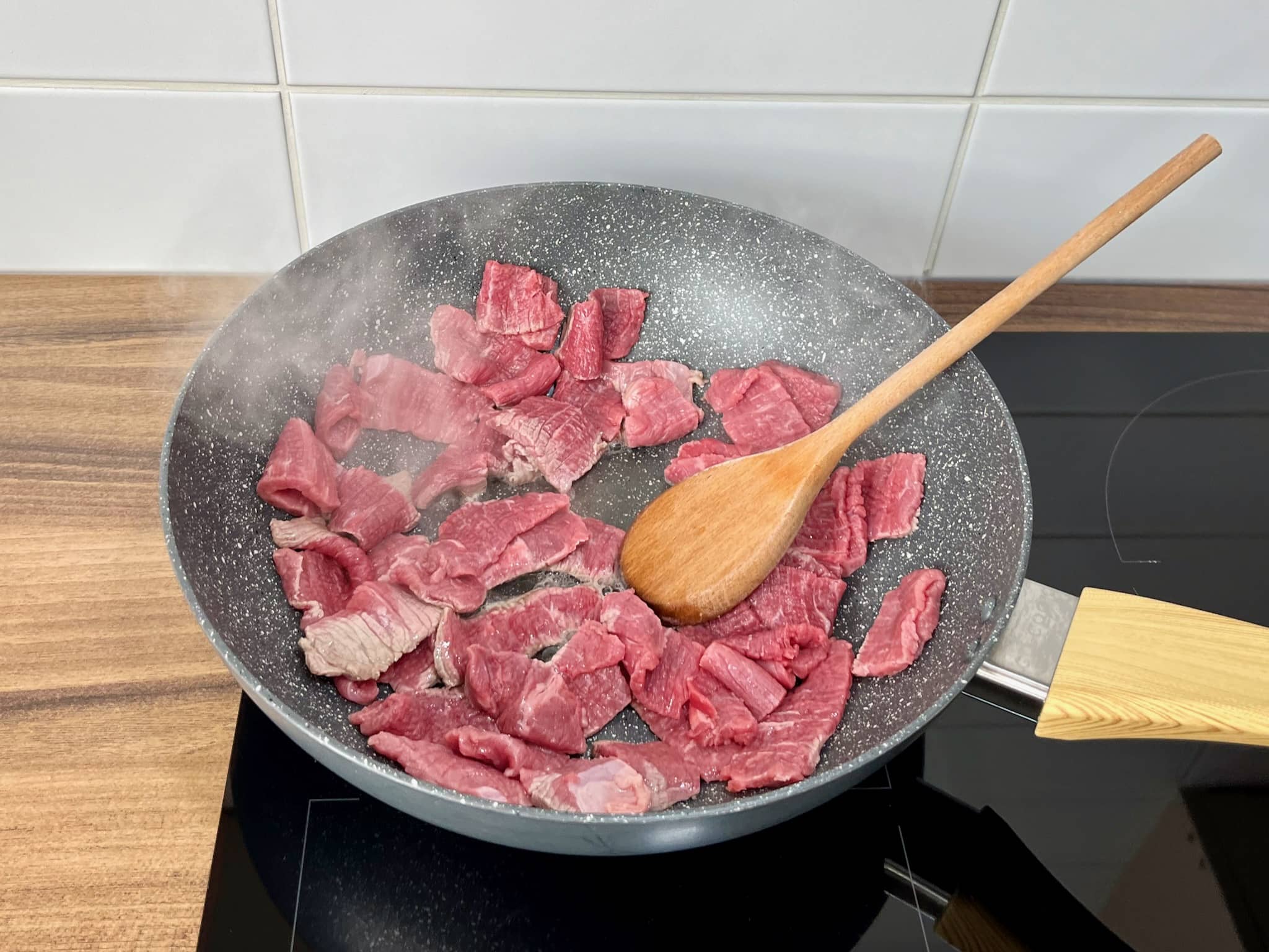 Steak meat slices are cooked in a large skillet
