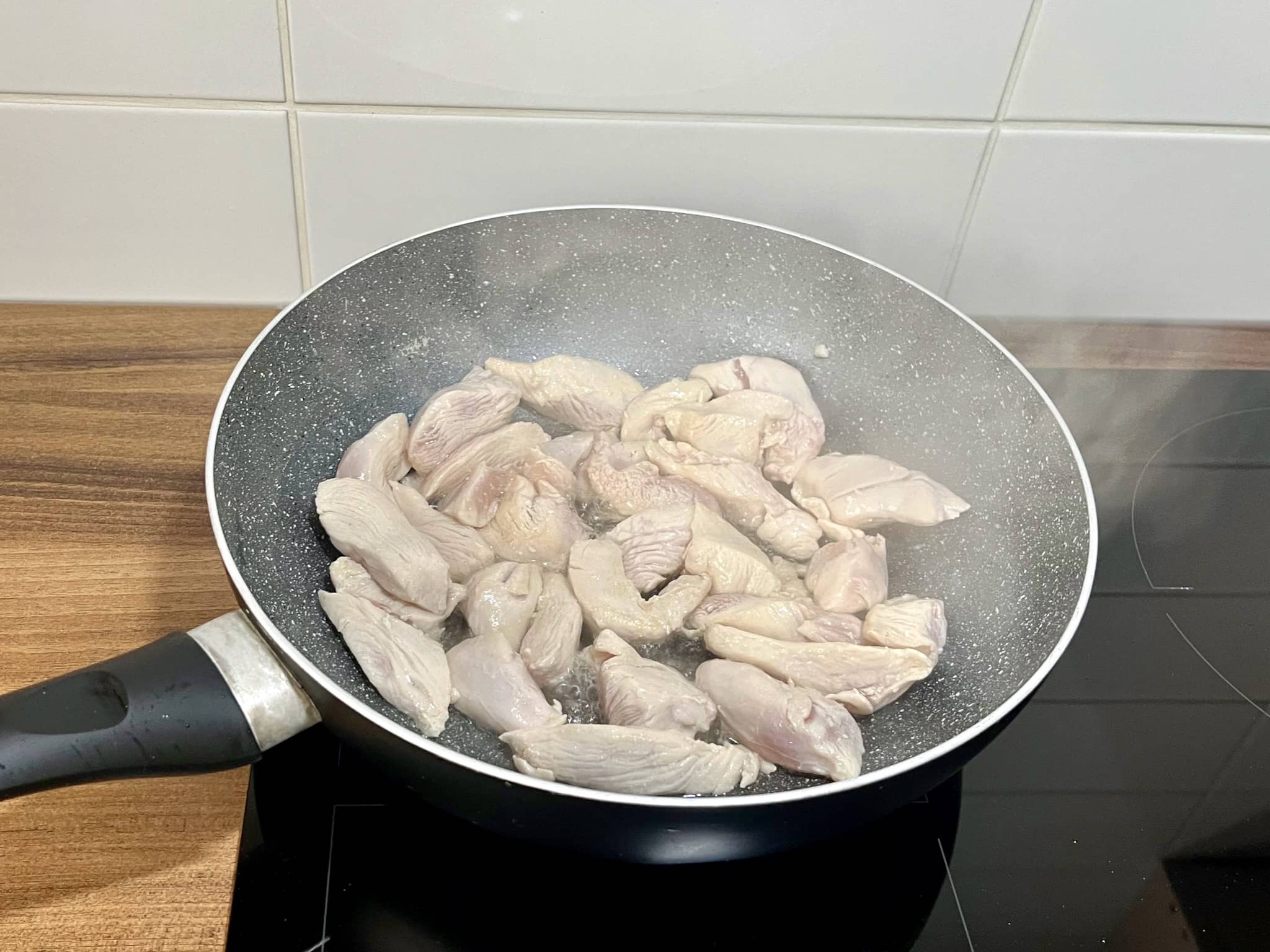 Lightly fried chicken breasts in a pan
