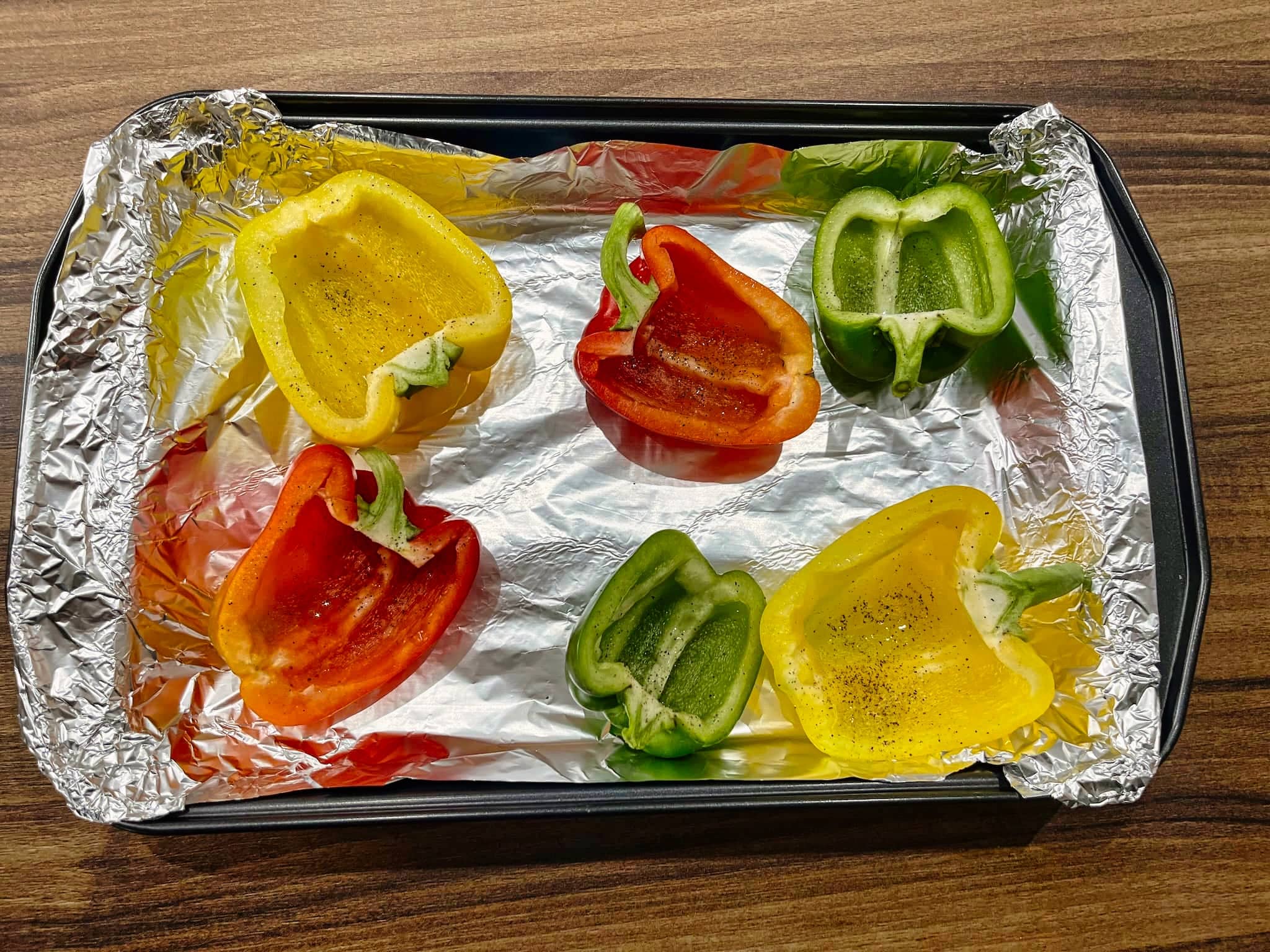 Halves of peppers prepared on a baking tray