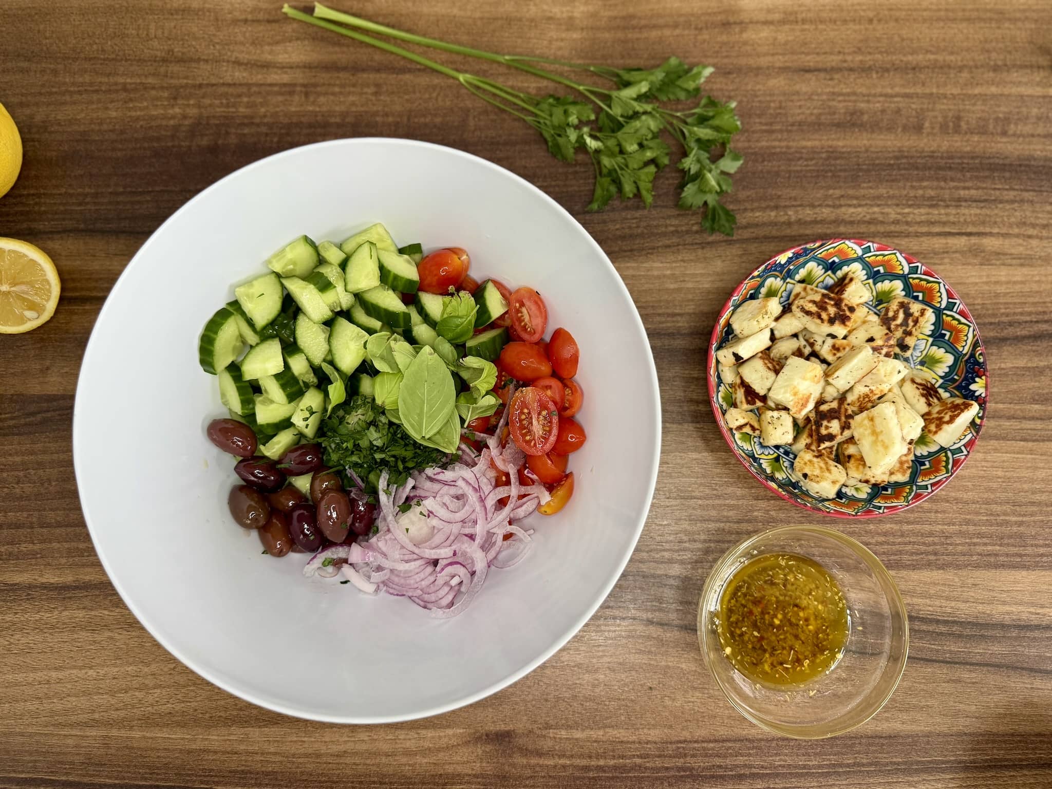 Bowl with ingredients in it, fried halloumi and dressing on the side