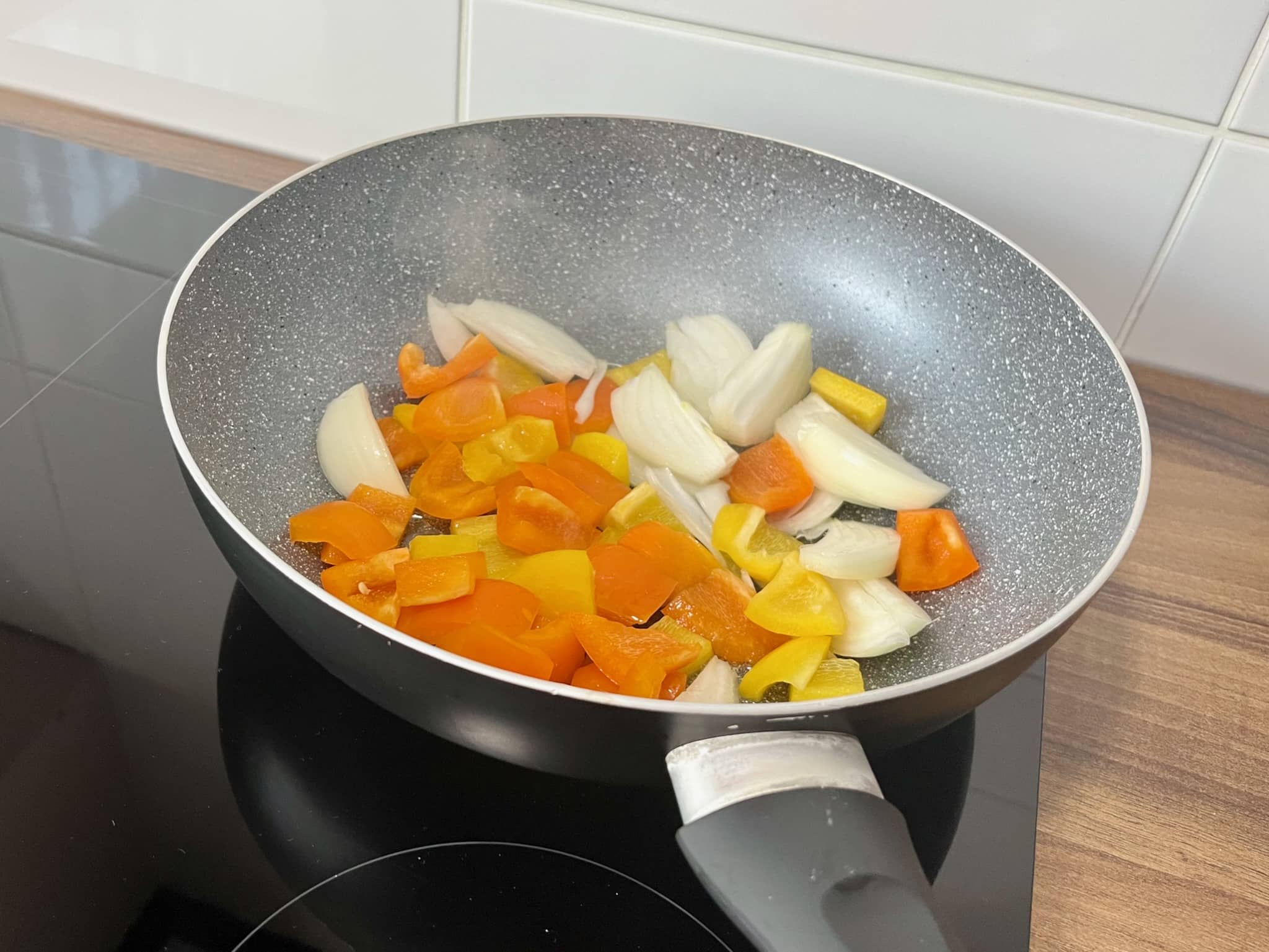 Onion and peppers stir fry in a pan