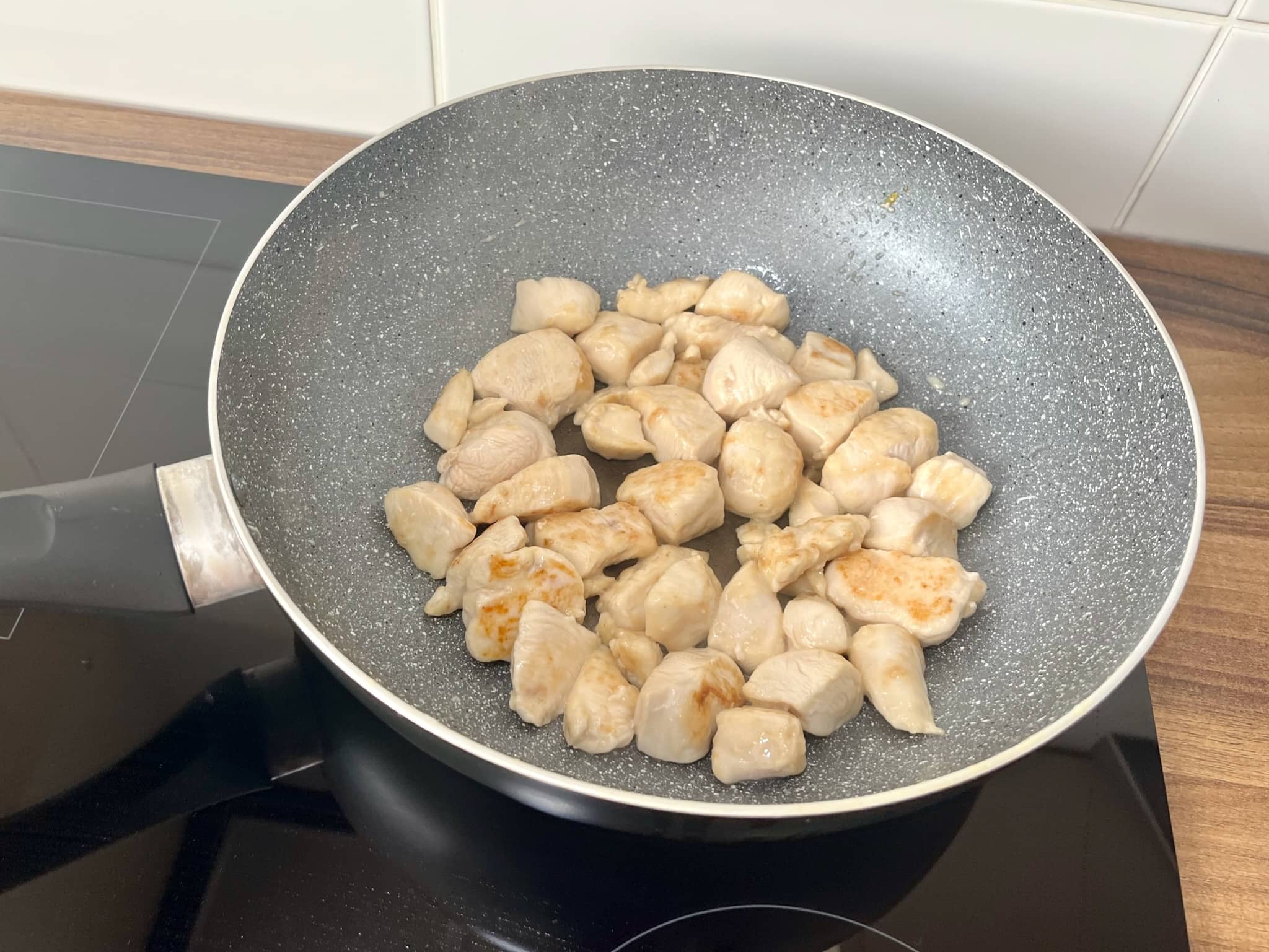 Diced chicken breast stir fry in a pan