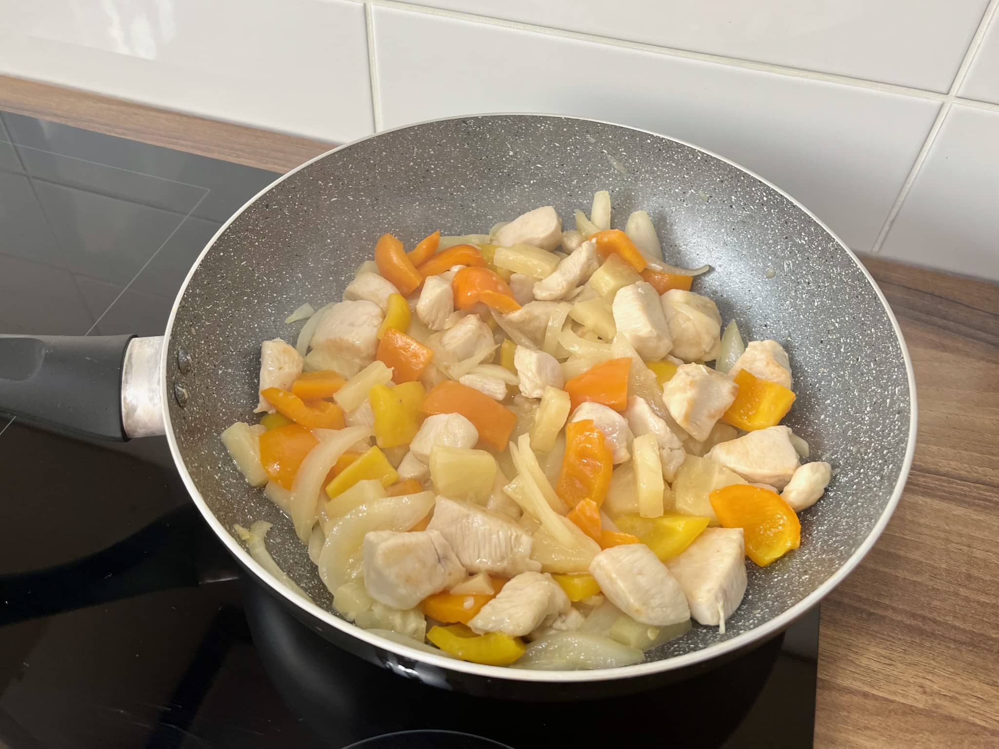 Chicken breasts and vegetables stir fry in a pan