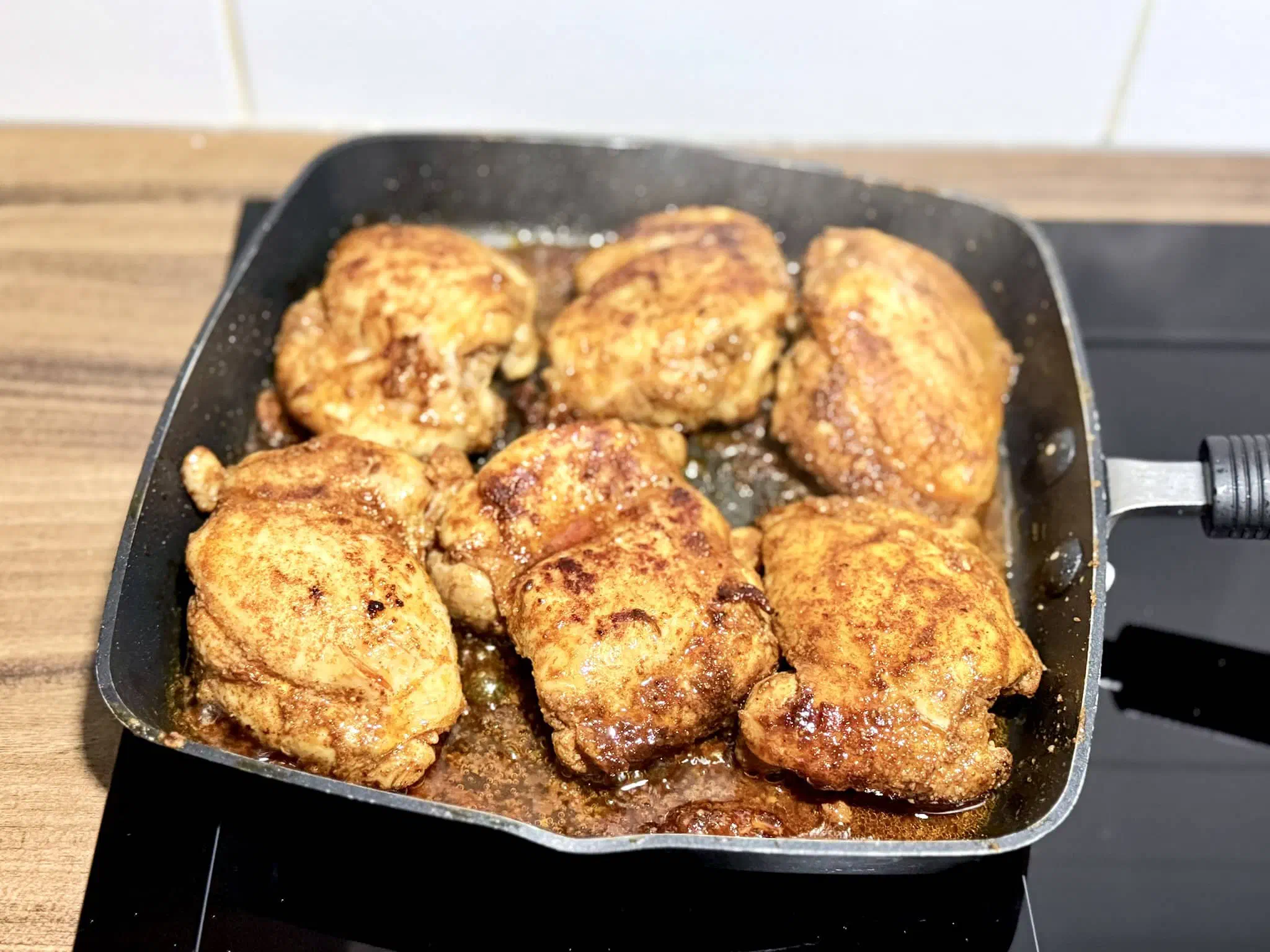 Beautifully fried golden chicken resting in a frying pan