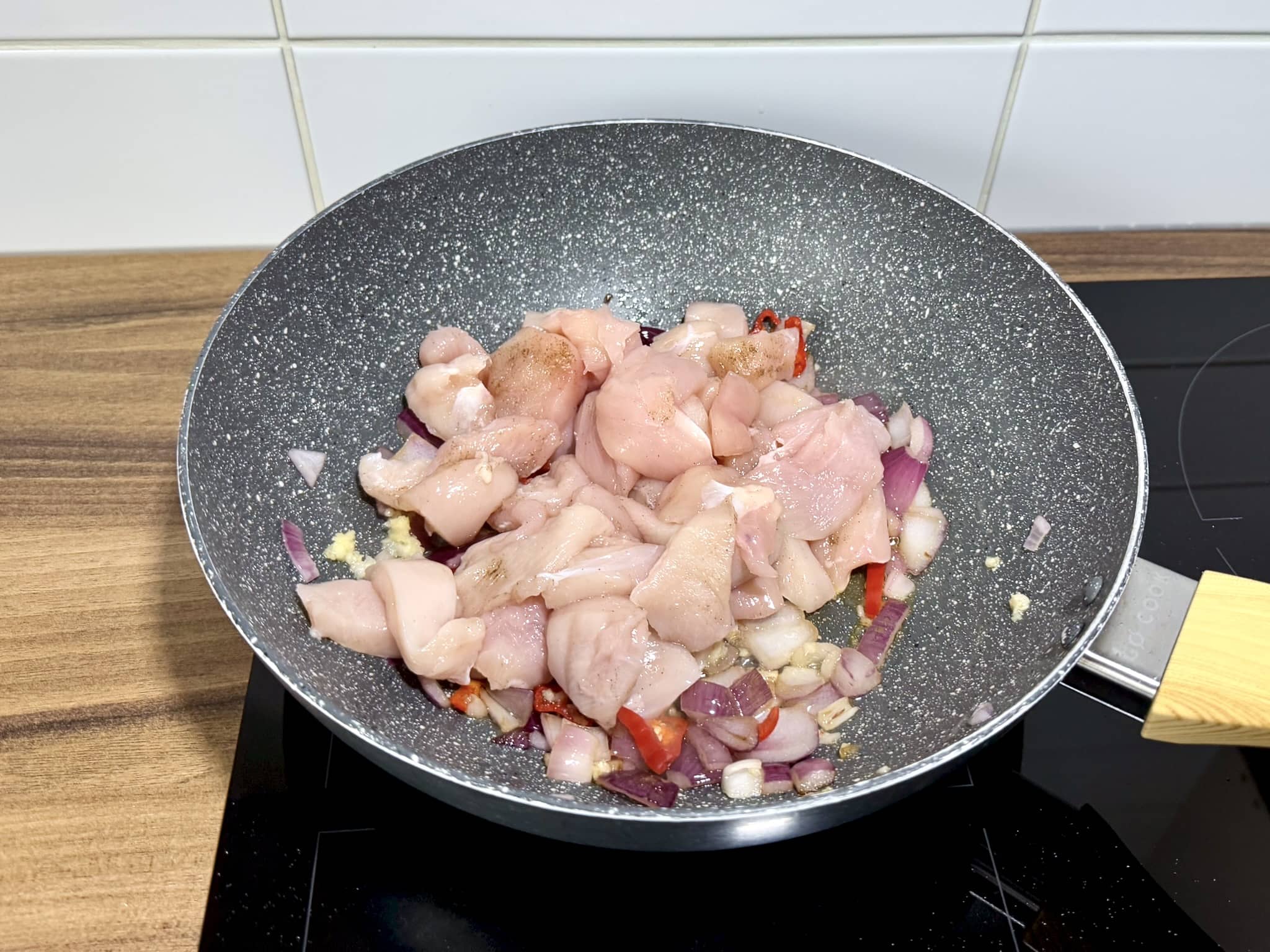 Diced chicken breast added to the pan