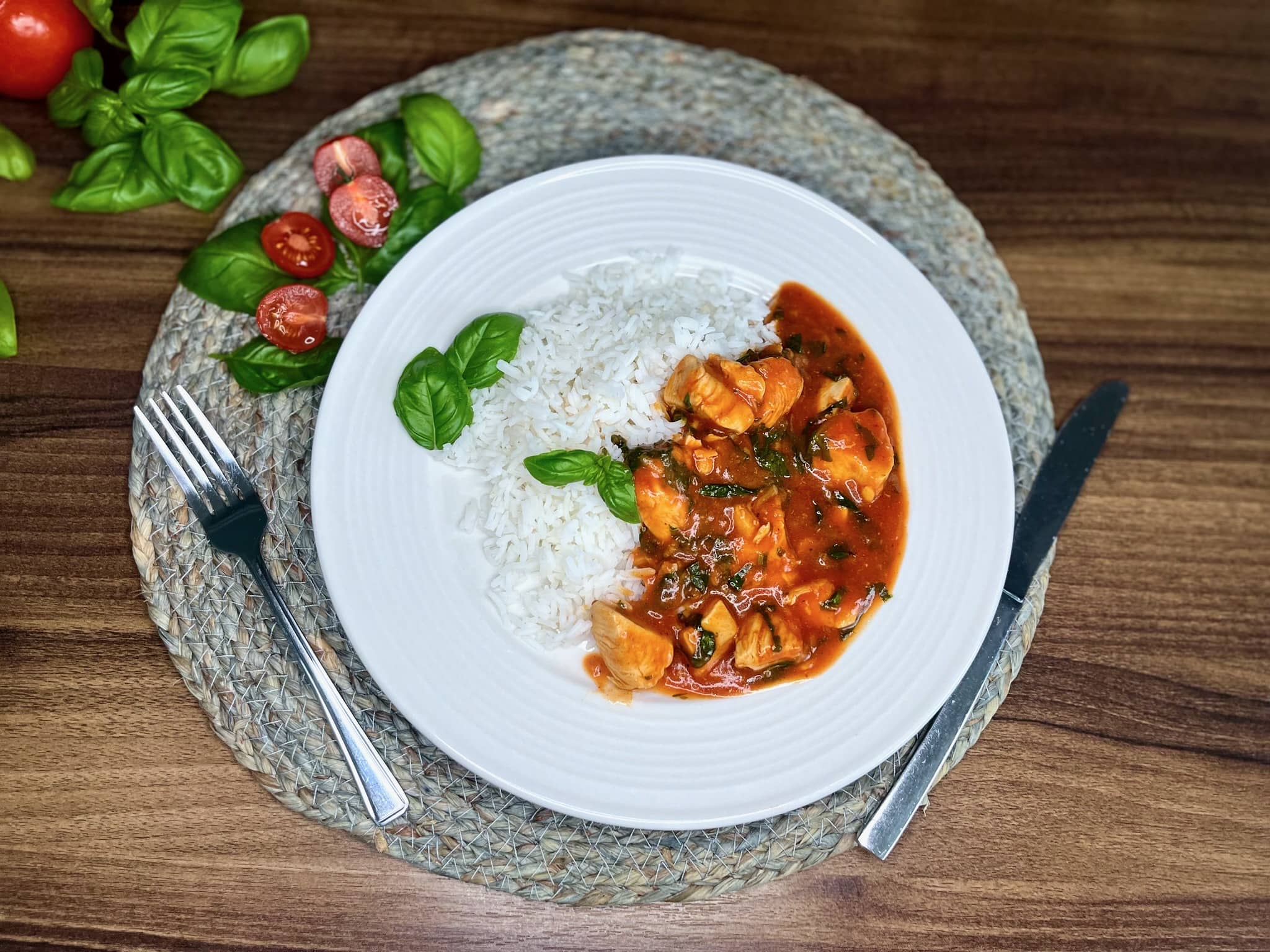 Tomato and Basil Chicken is beautifully served with rice on a plate