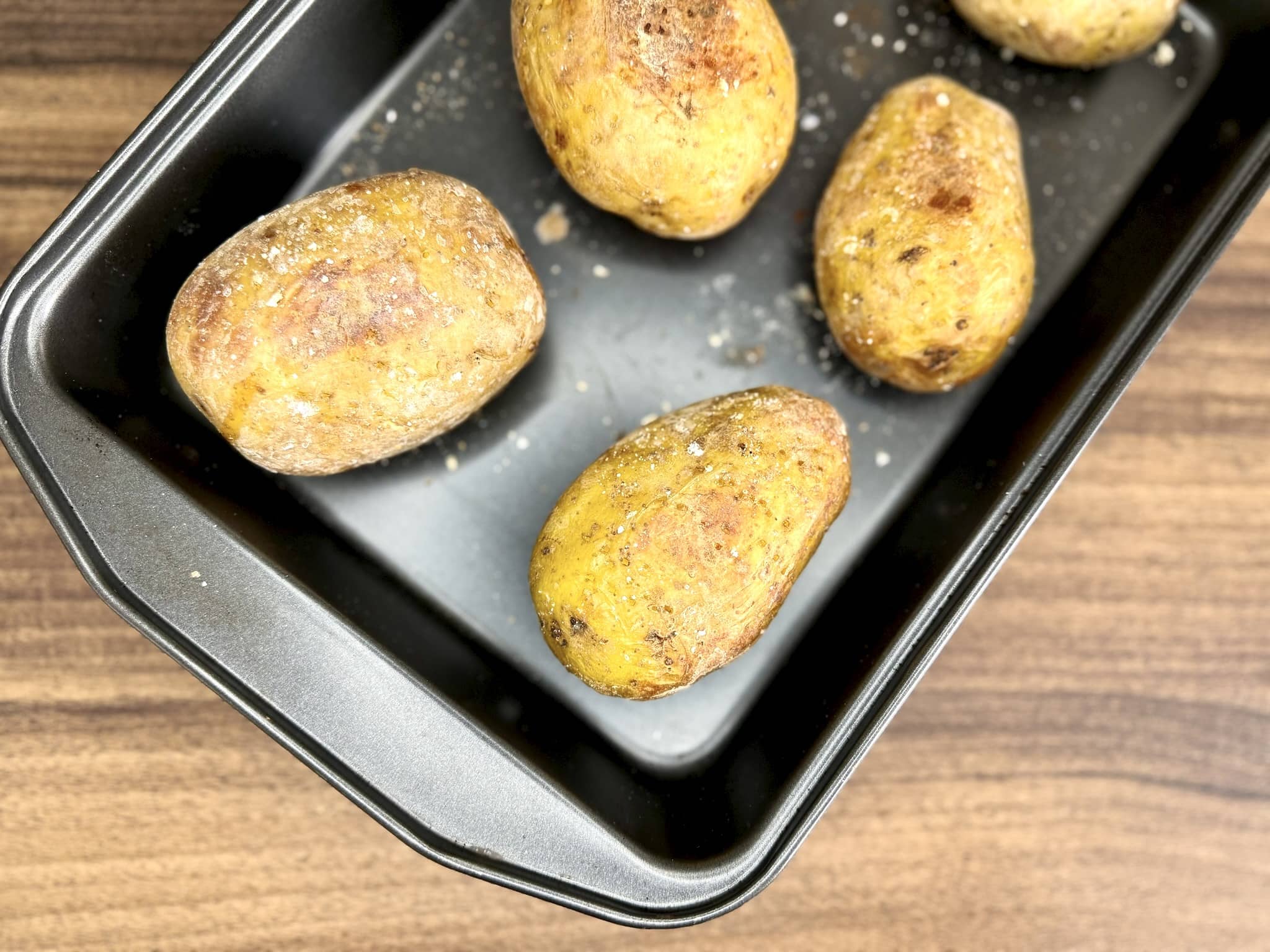 Baked potatoes unwrapped from tin foil after final baking to create a crisp skin