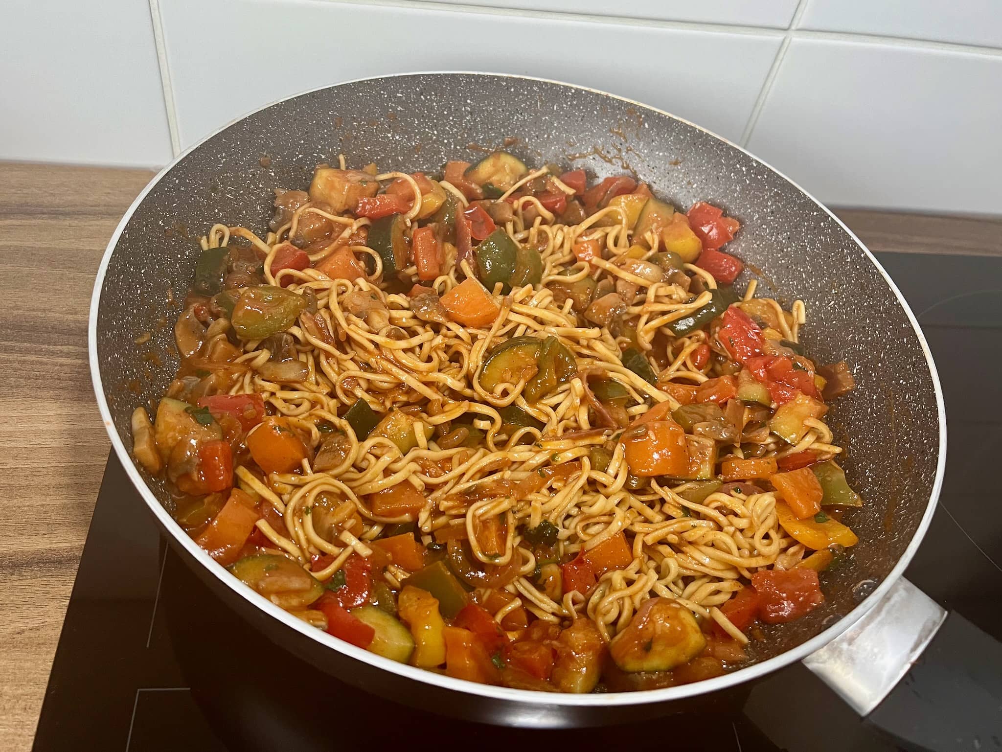Noodles and vegetable stew mixed together in a pan