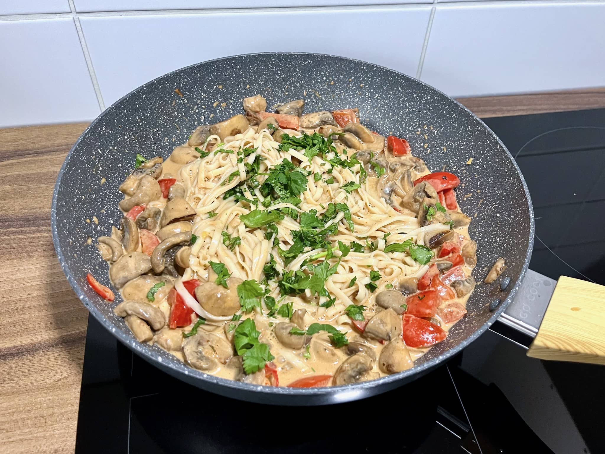 A pan of Udon noodles sizzles with Thai Curry, brightened by coriander and lime juice