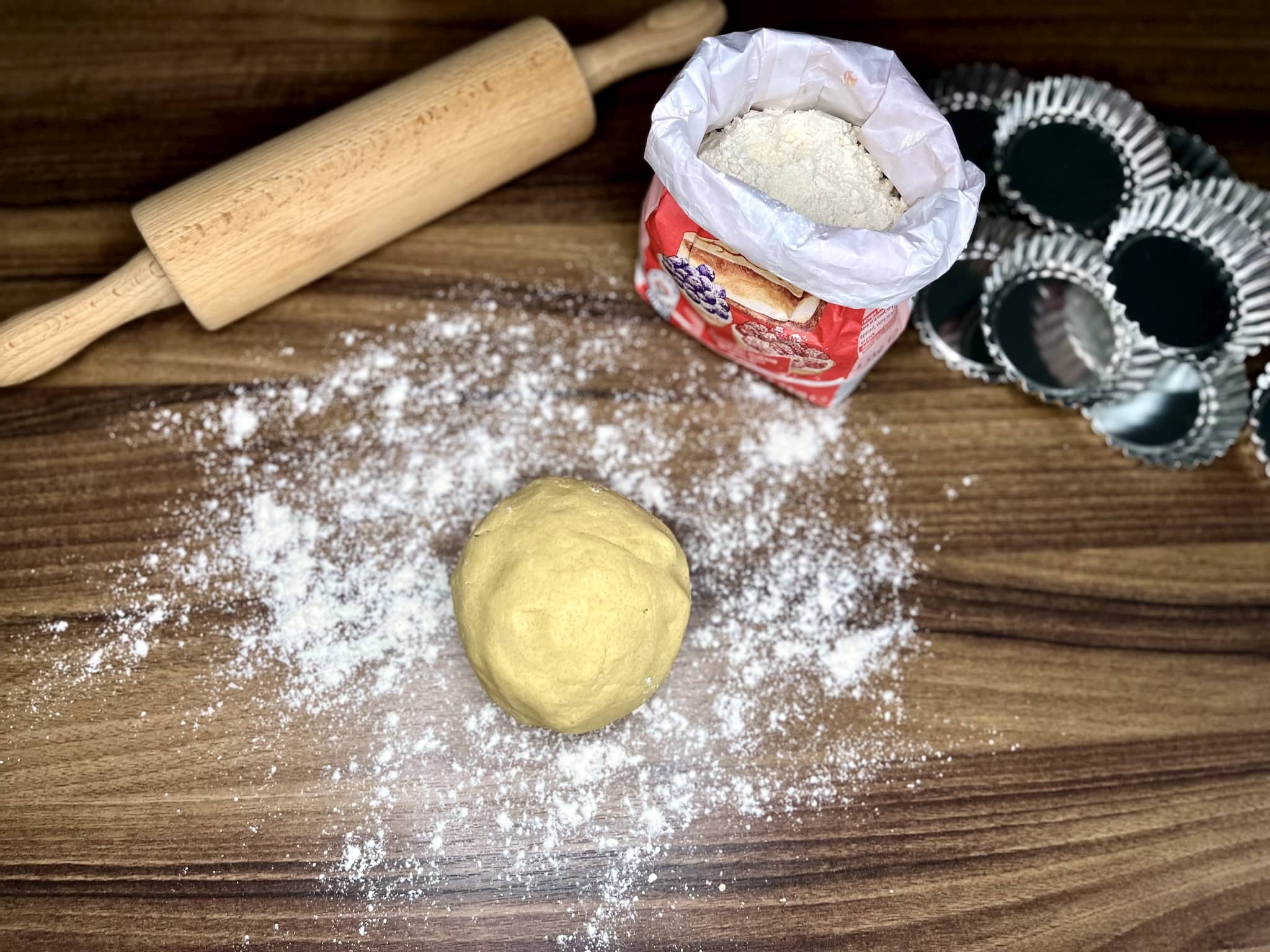 Kulka ciasta kruchego na posypanej mąką powierzchni
