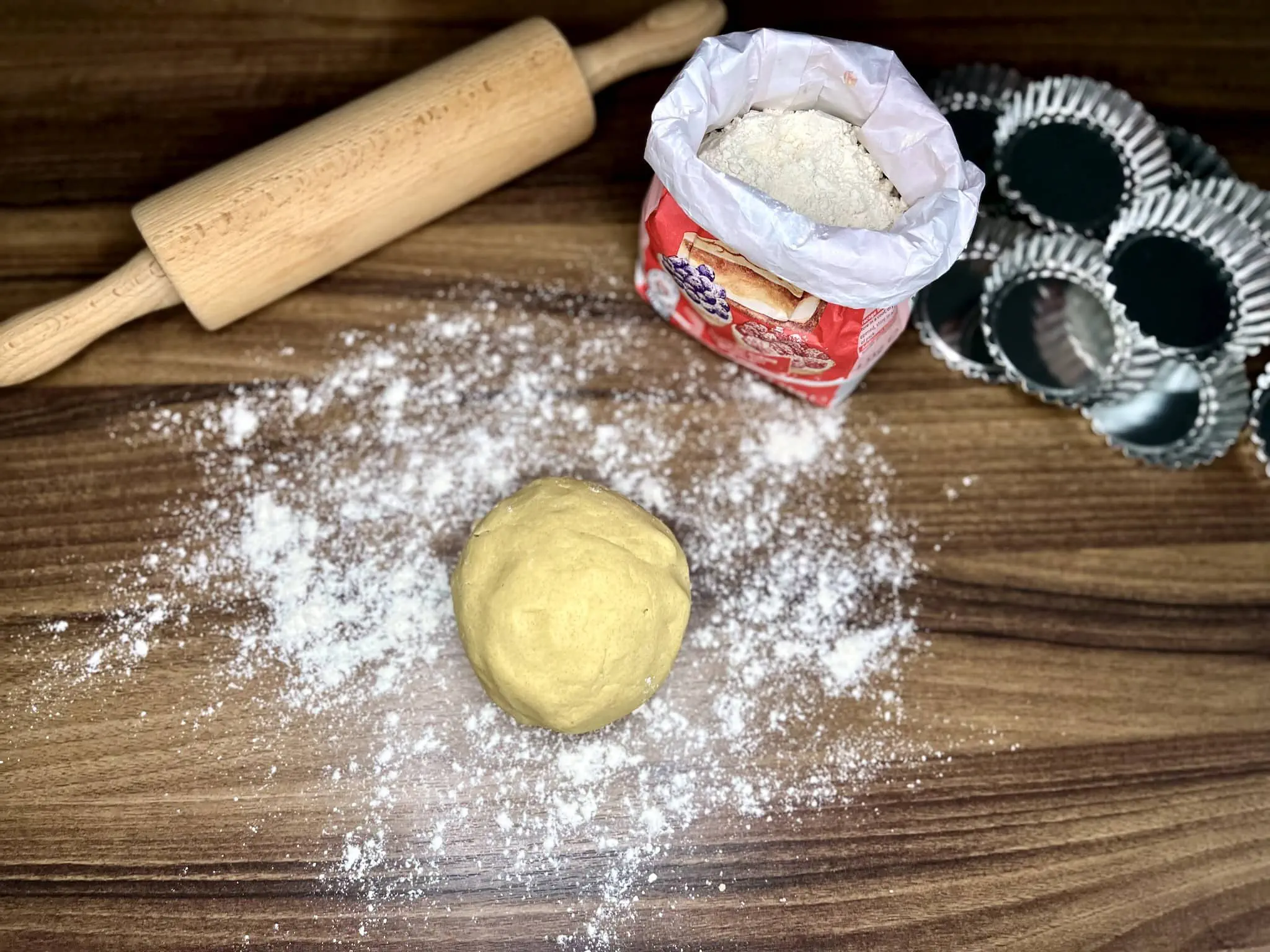 Kulka ciasta kruchego na posypanej mąką powierzchni