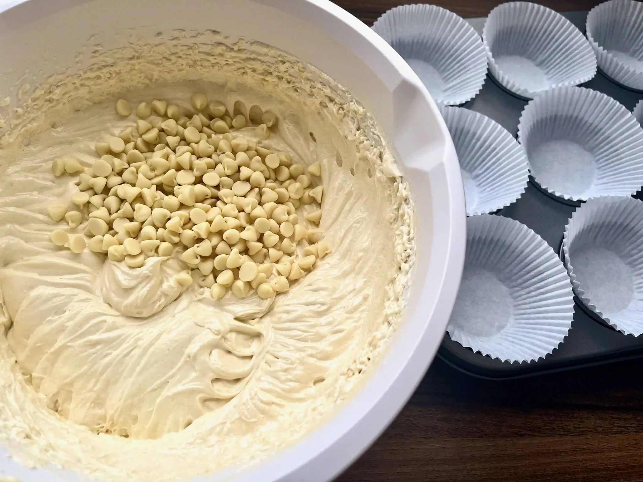 Batter in bowl, chips on top. Muffin tray waits