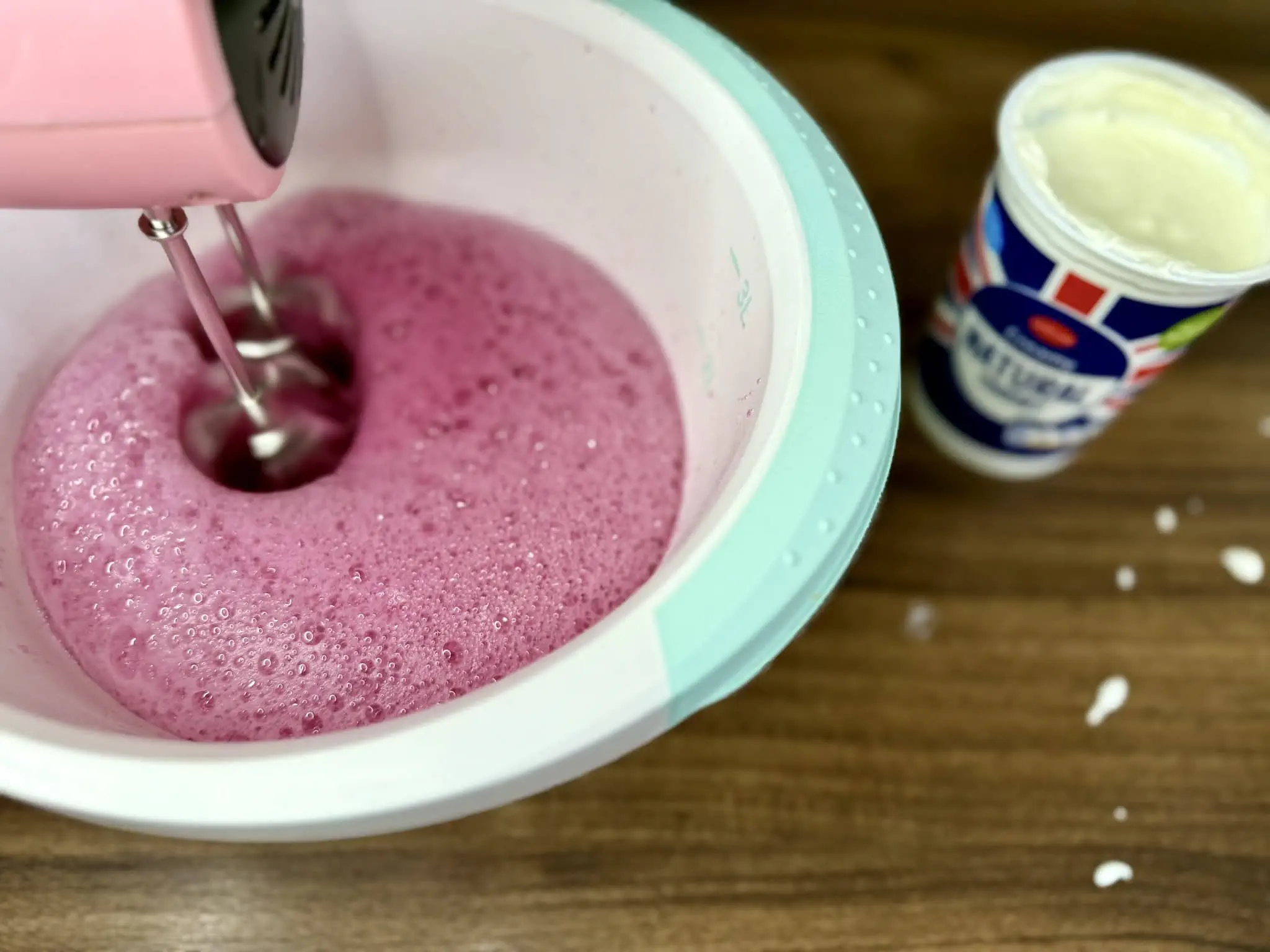 Mixing liquid jelly mix with natural yoghurt in a mixing bowl